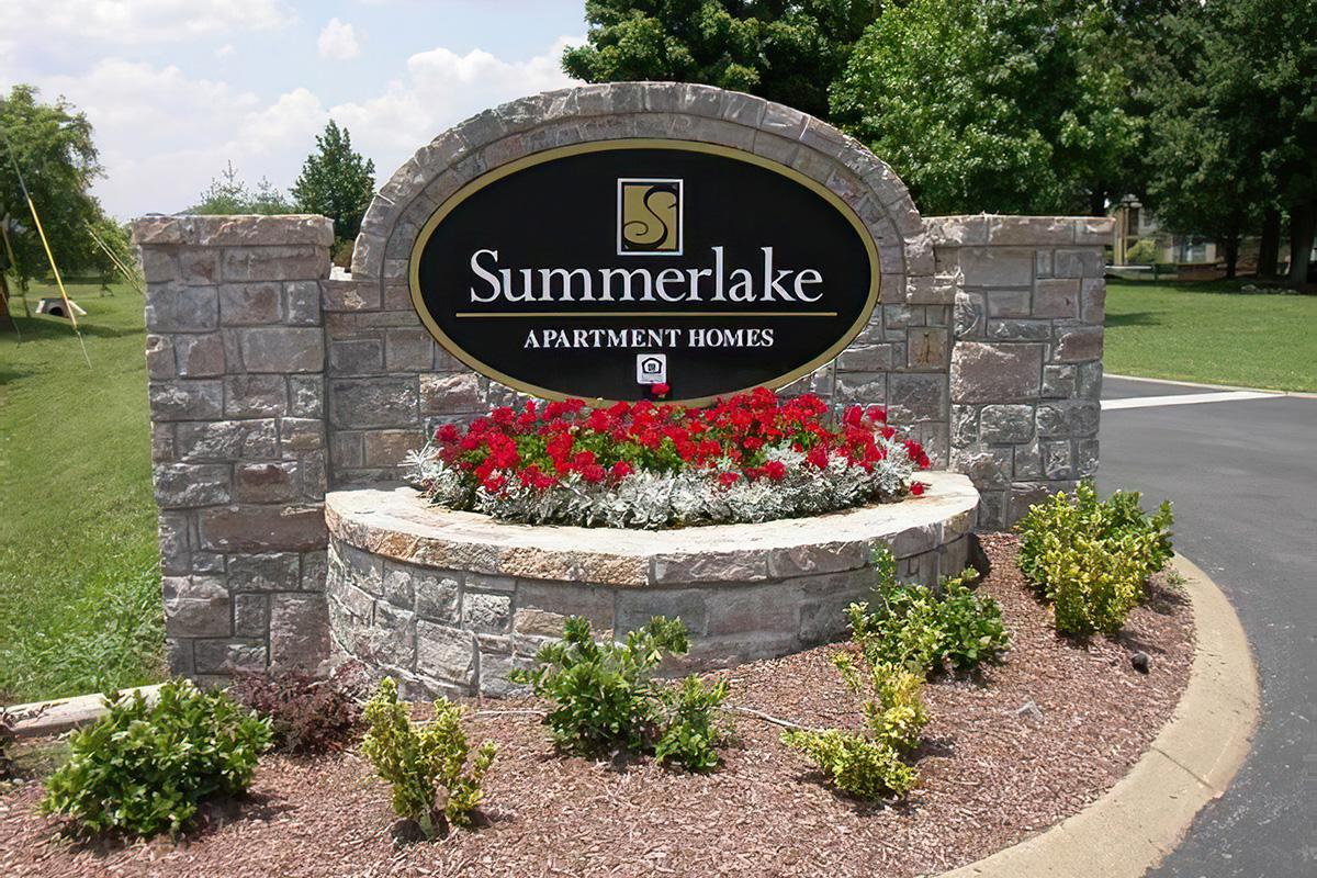 a sign on the side of a flower garden