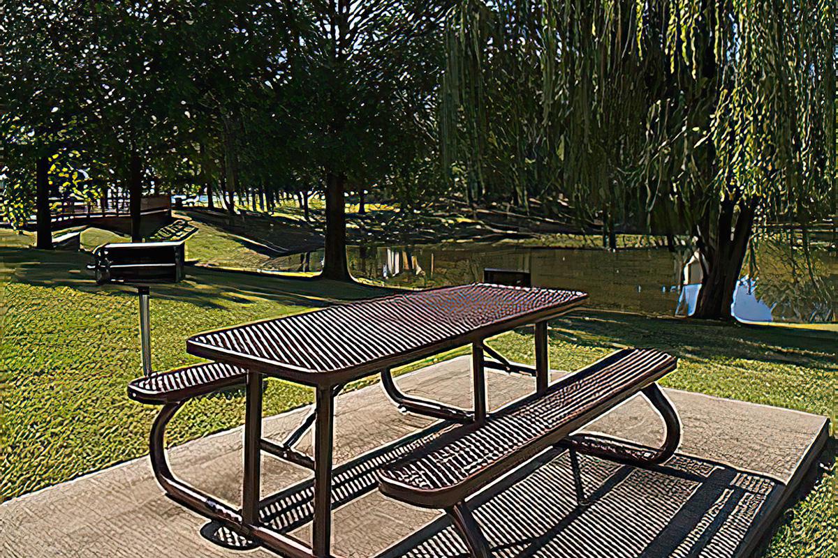 an empty park bench sitting in the grass