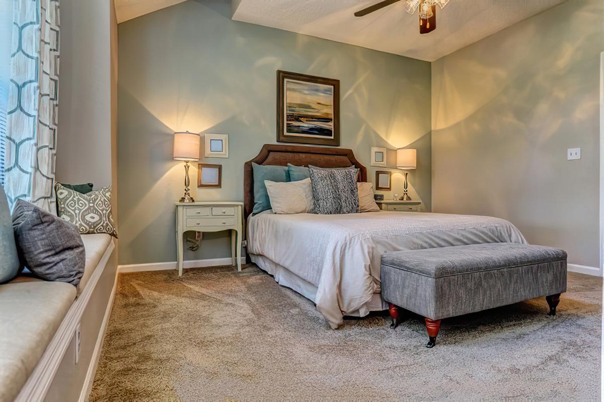 a bedroom with a bed and a chair in a room