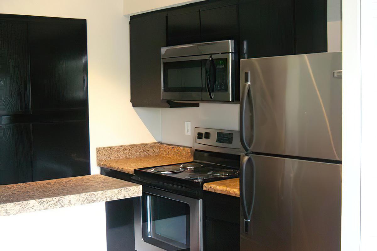 a stove top oven sitting inside of a kitchen with stainless steel appliances