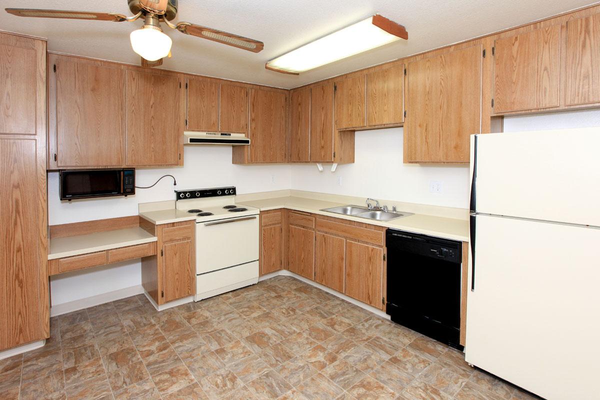 a kitchen with wooden cabinets and a wood floor