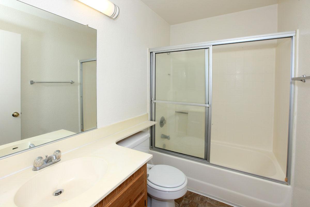 a white sink sitting next to a glass shower door