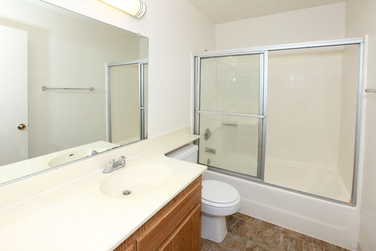 a white sink sitting next to a glass shower door