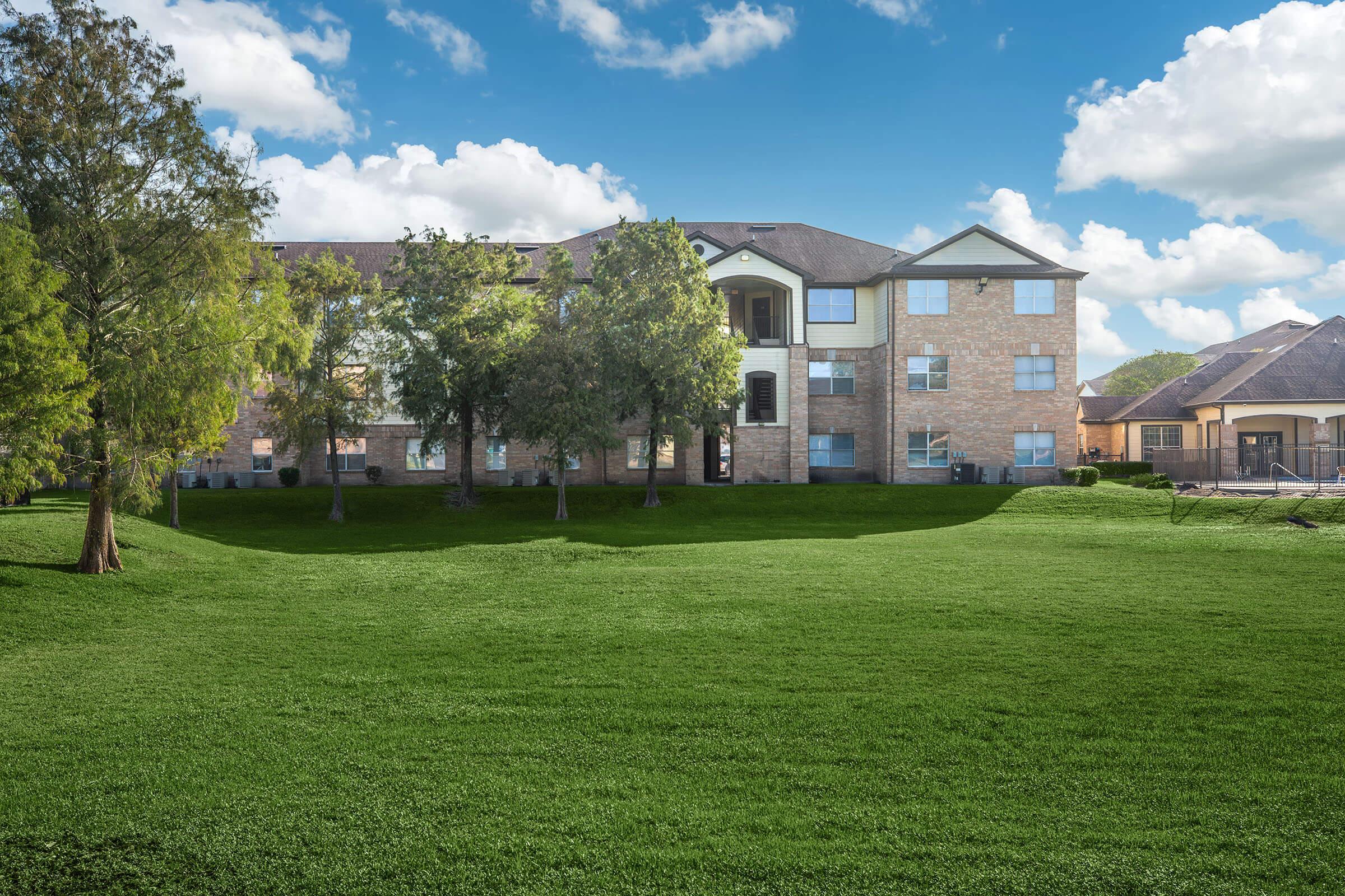 a large green field in front of a house