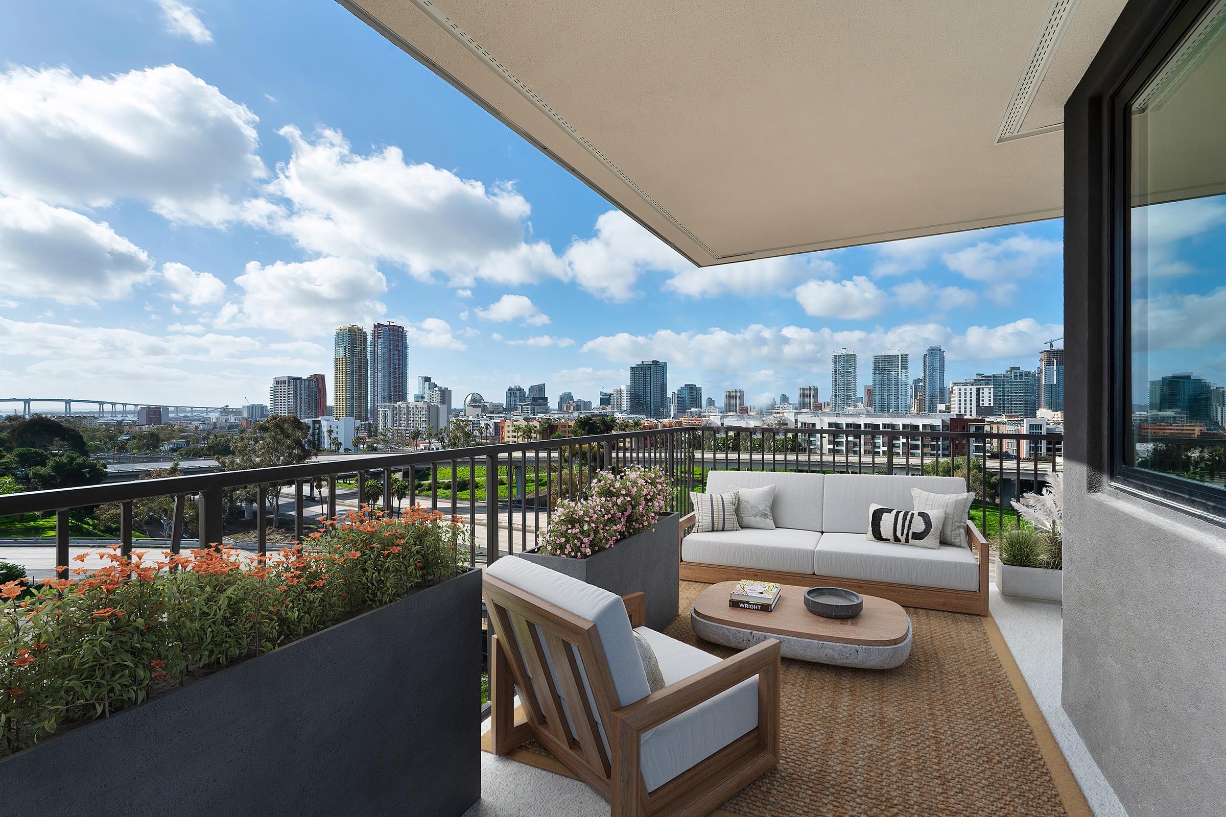 A modern balcony with comfortable seating overlooks a vibrant city skyline. Bright flowers decorate the planters, while skyscrapers and clouds fill the background. The scene captures a blend of urban living and outdoor relaxation in a sunny atmosphere.