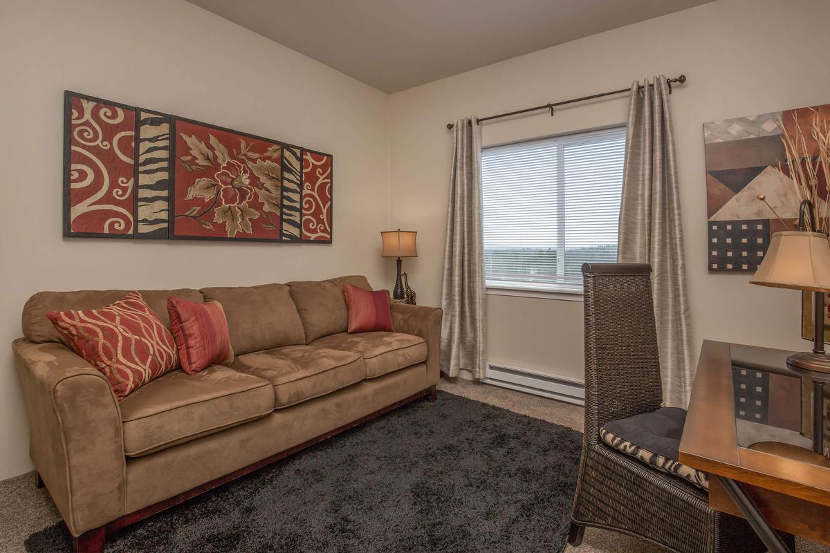 a living room filled with furniture and a large window
