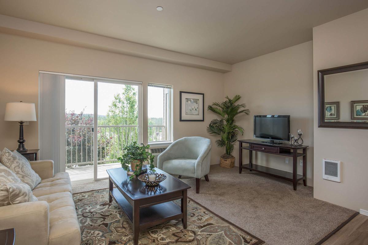 a living room filled with furniture and a large window