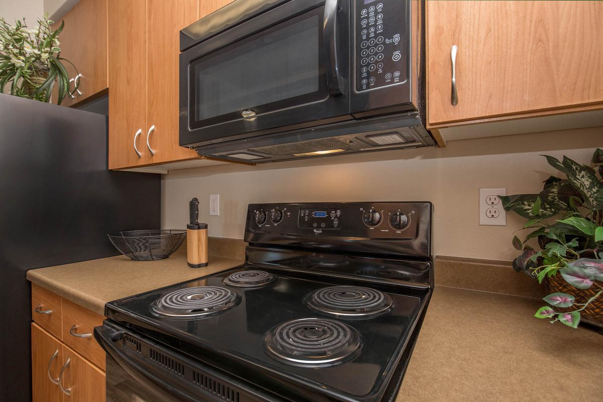 a black stove top oven sitting inside of a kitchen