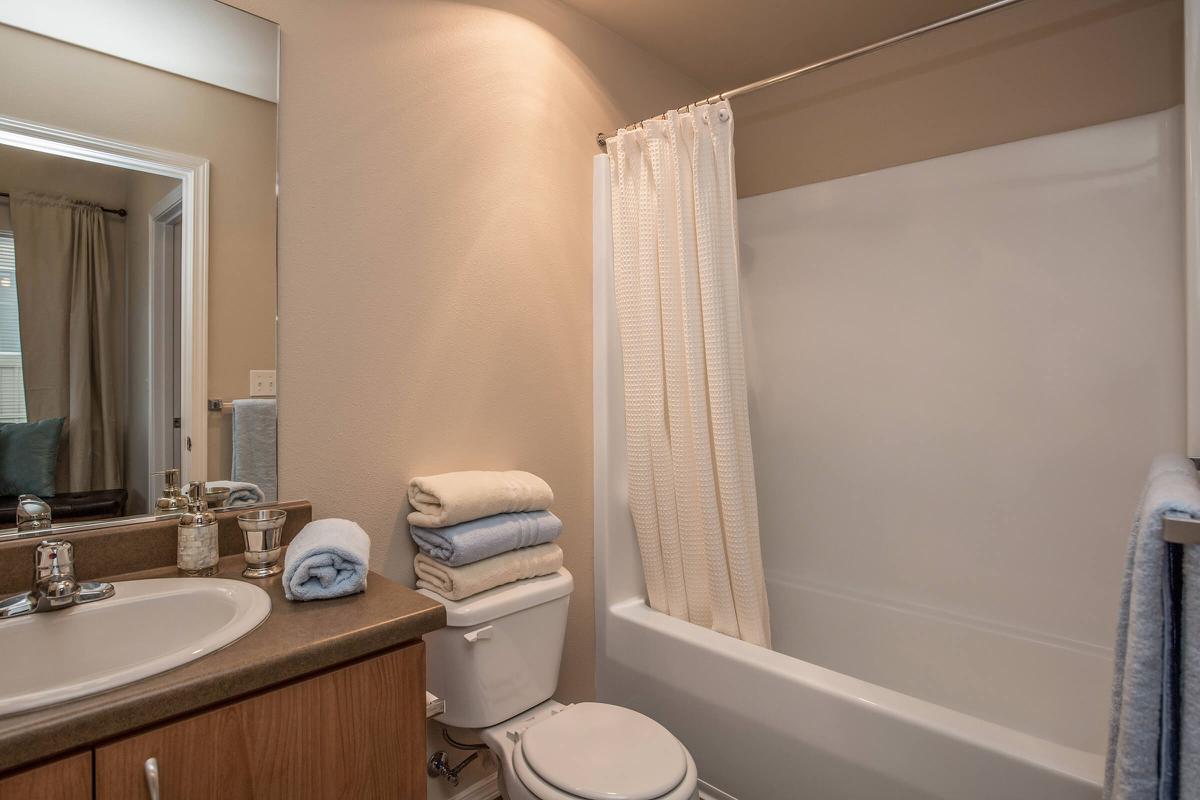 a white tub sitting next to a sink and a mirror