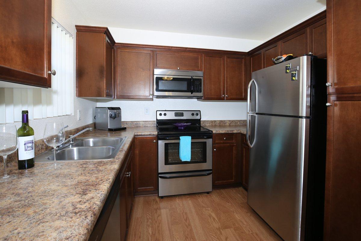 a modern kitchen with stainless steel appliances and wooden cabinets