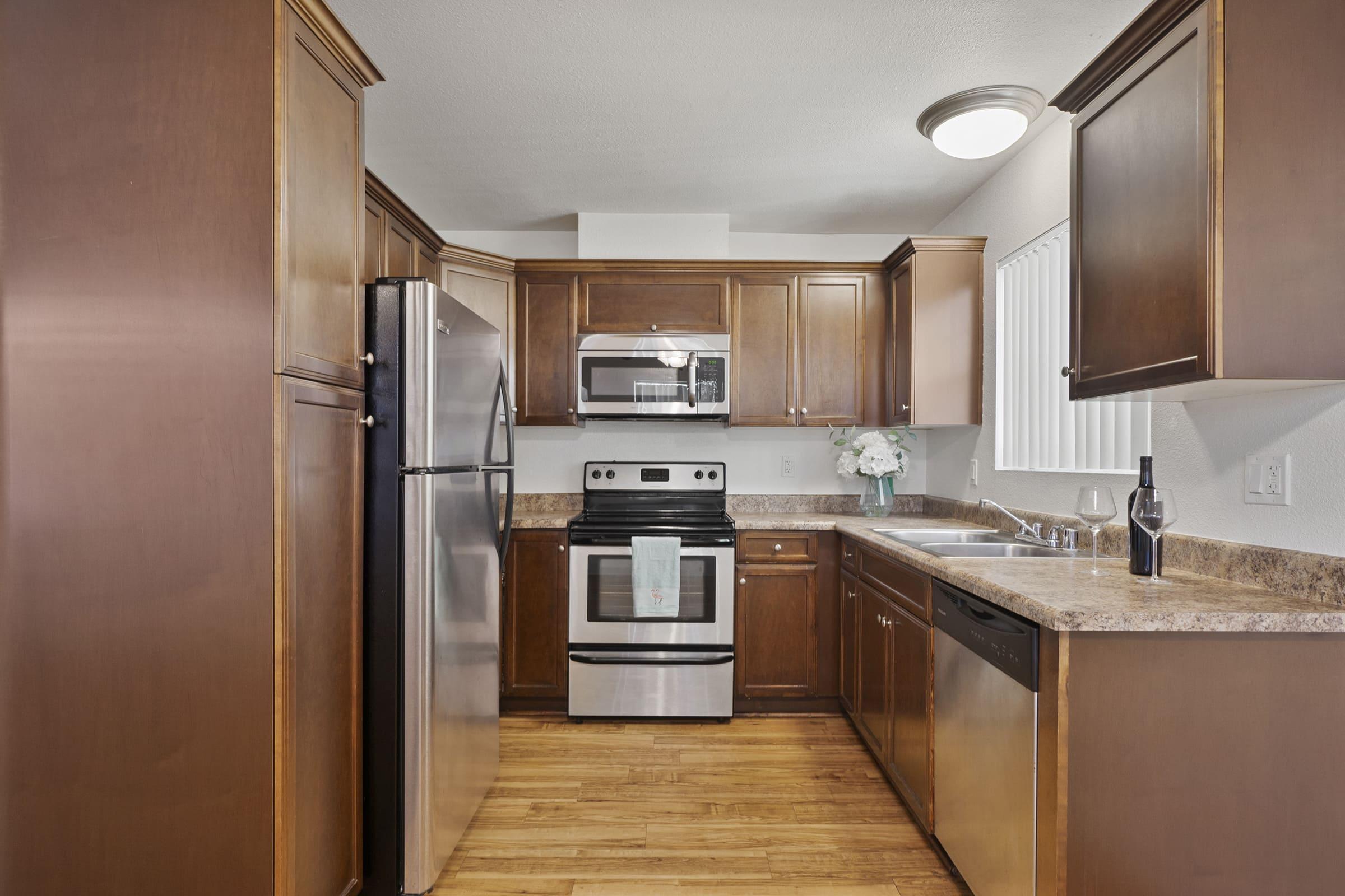 a large kitchen with stainless steel appliances and wooden cabinets