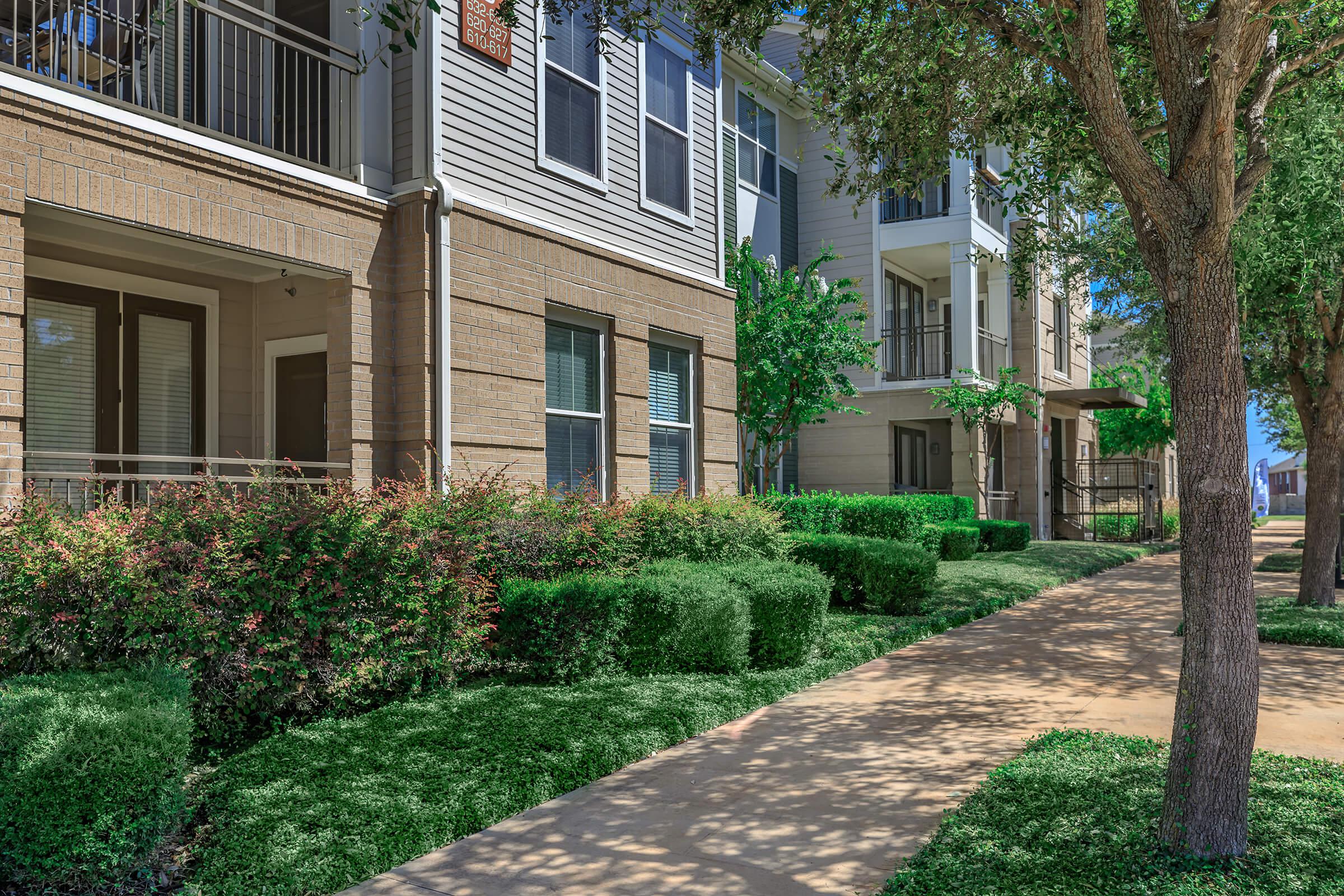 a garden in front of a brick building