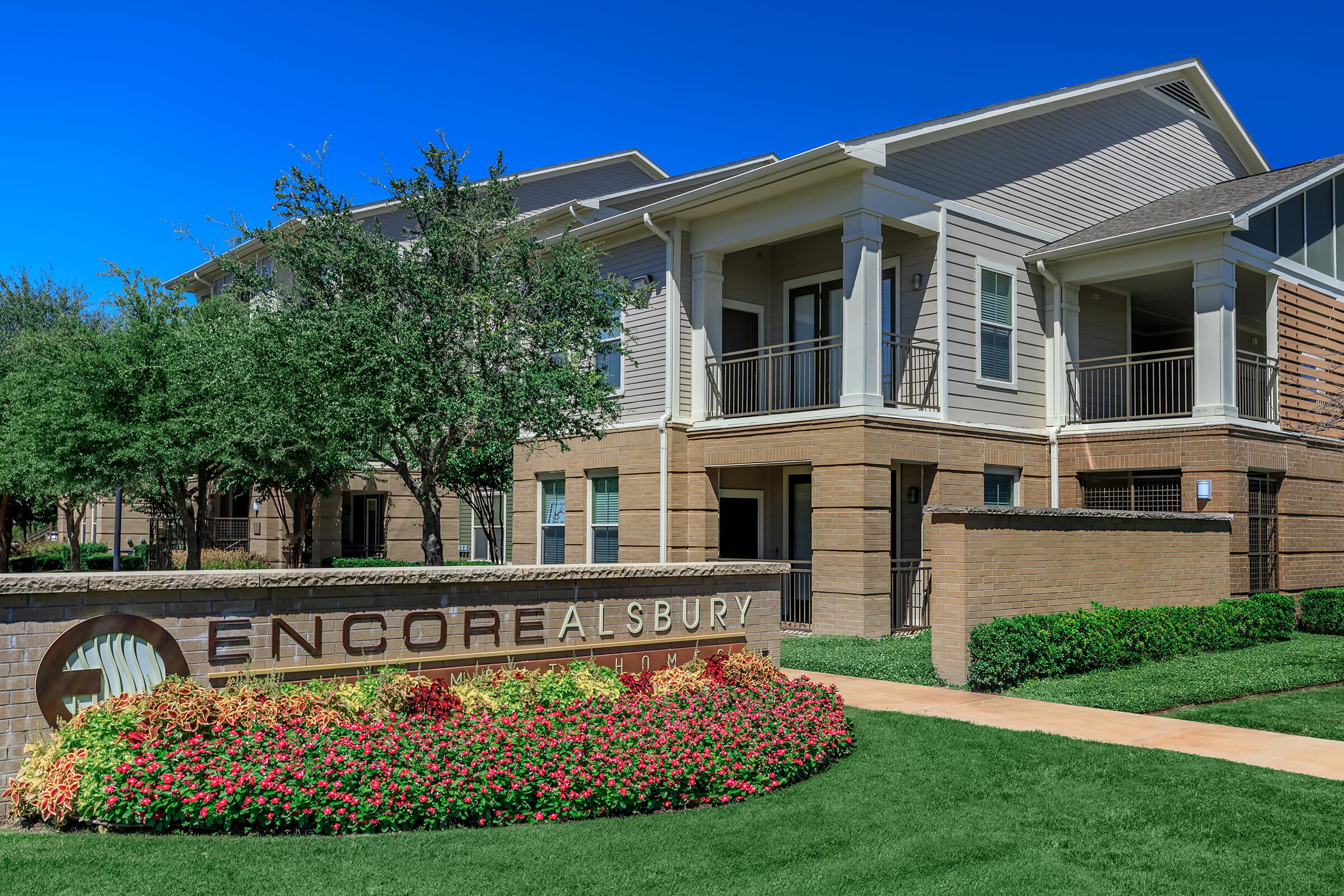 a close up of a flower garden in front of a building