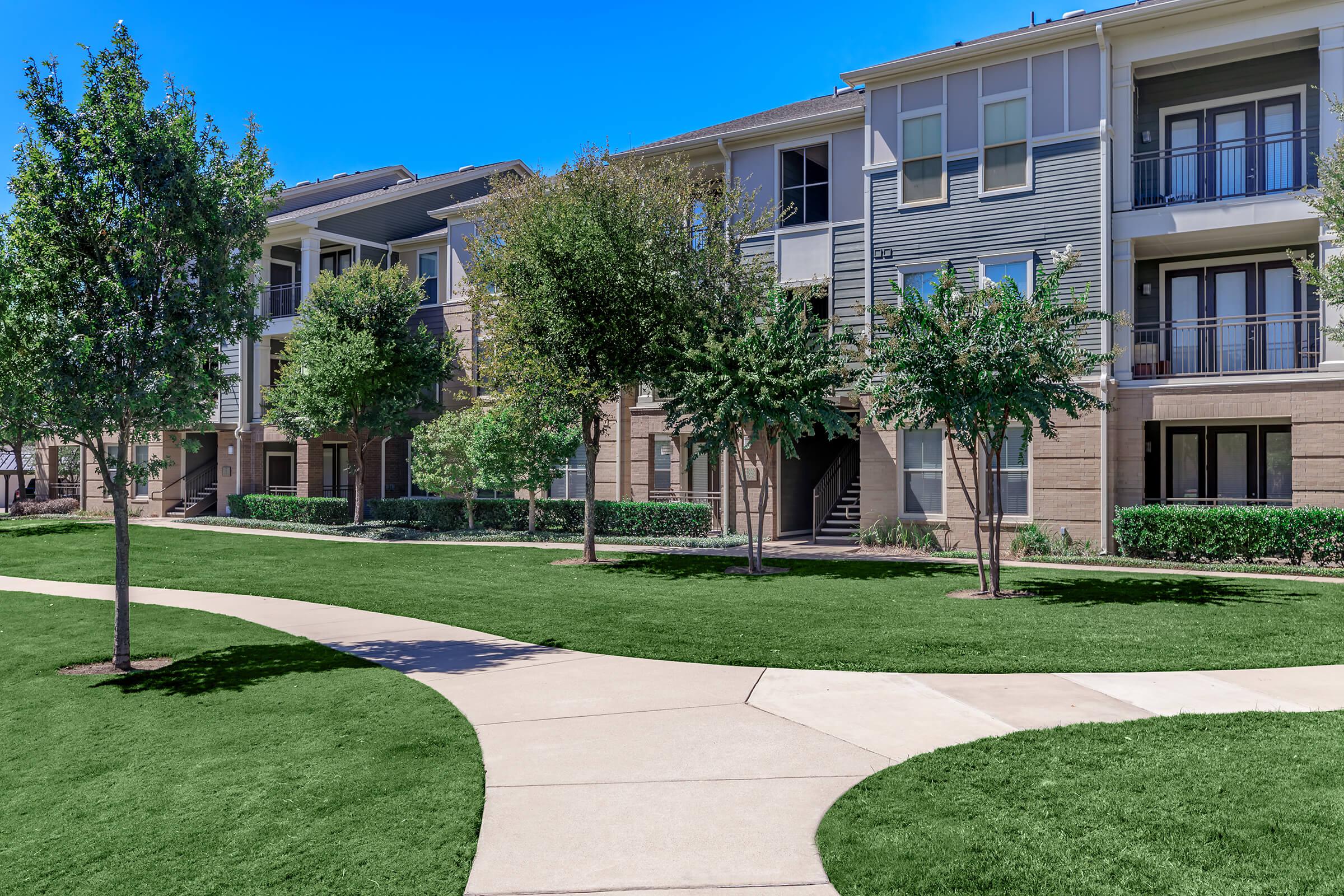 a large lawn in front of a brick building