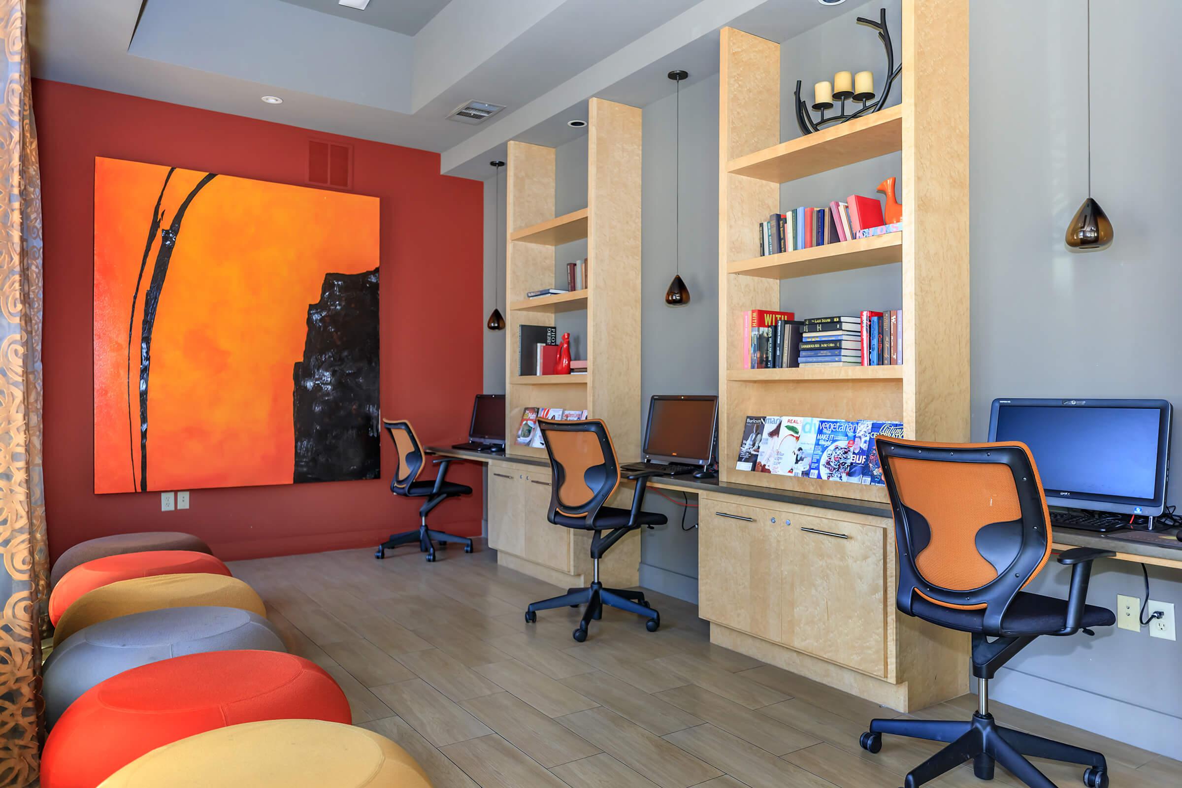 a desk with a computer and a chair in a room