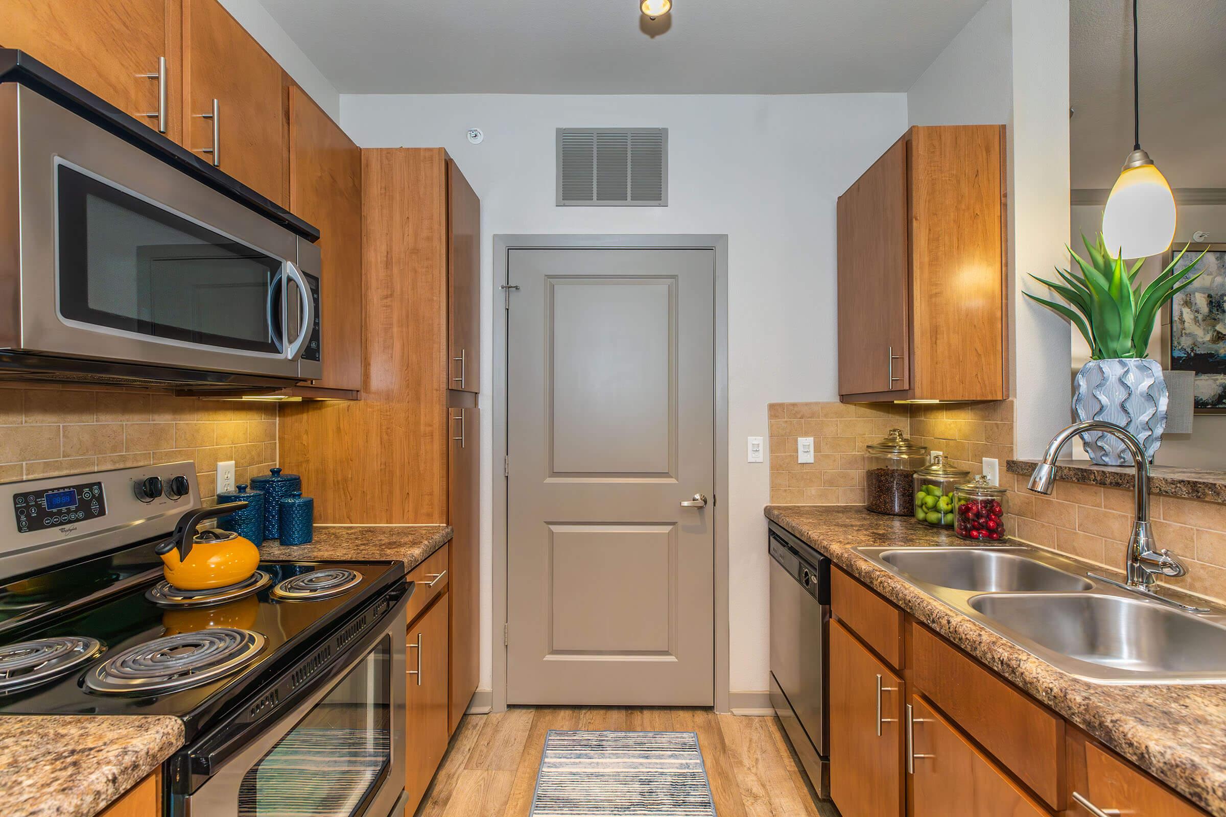 a kitchen with a stove a sink and a microwave oven on a counter