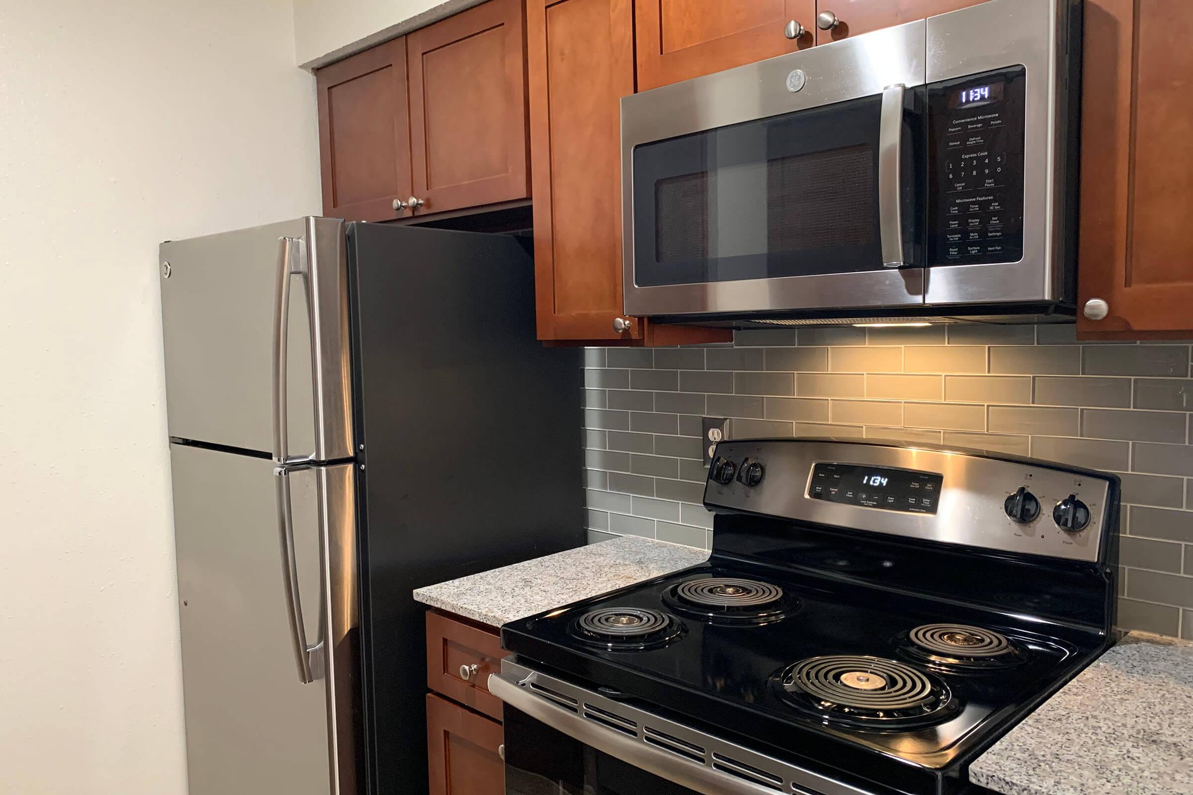 a stove top oven sitting inside of a kitchen with stainless steel appliances