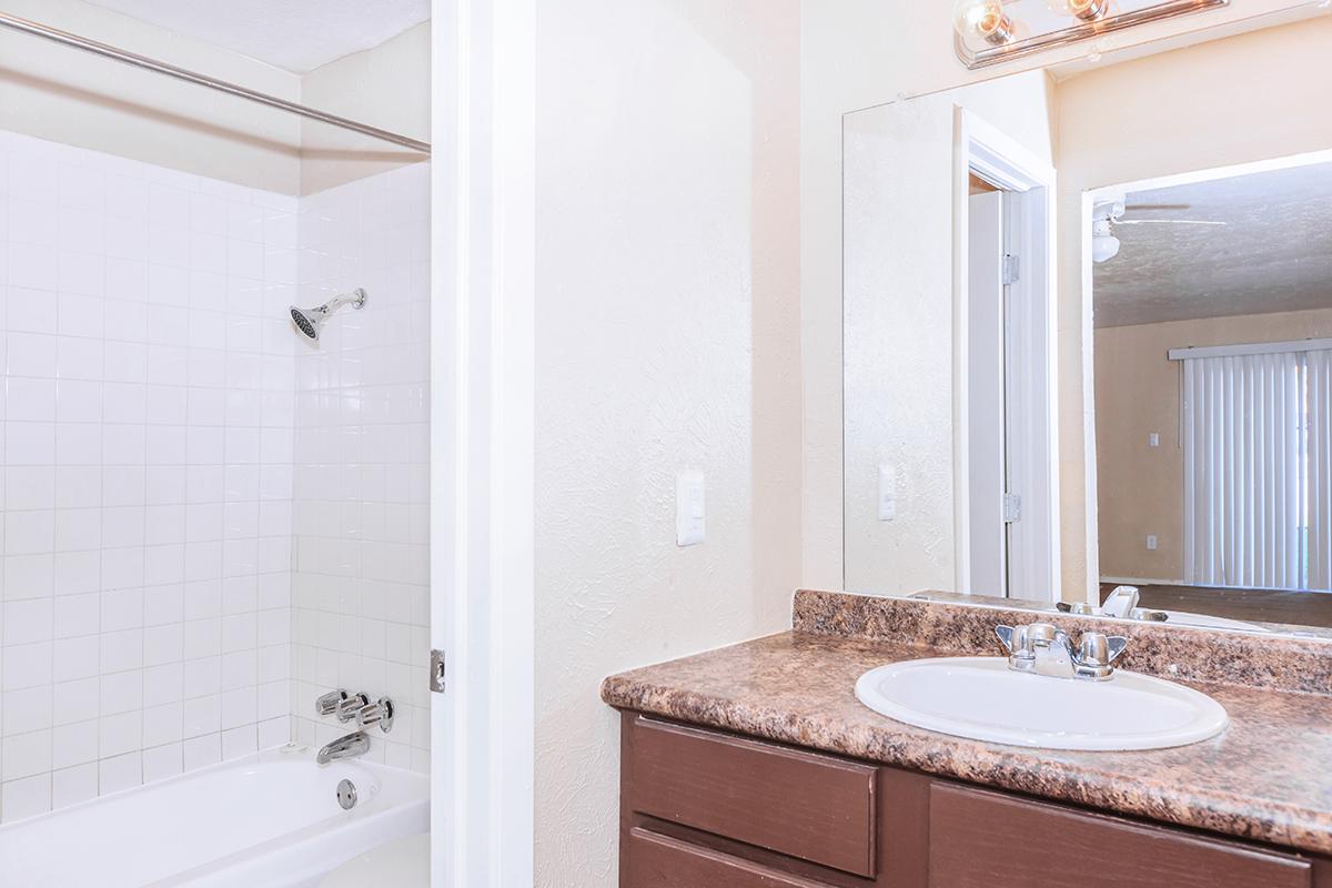 a white sink sitting under a mirror