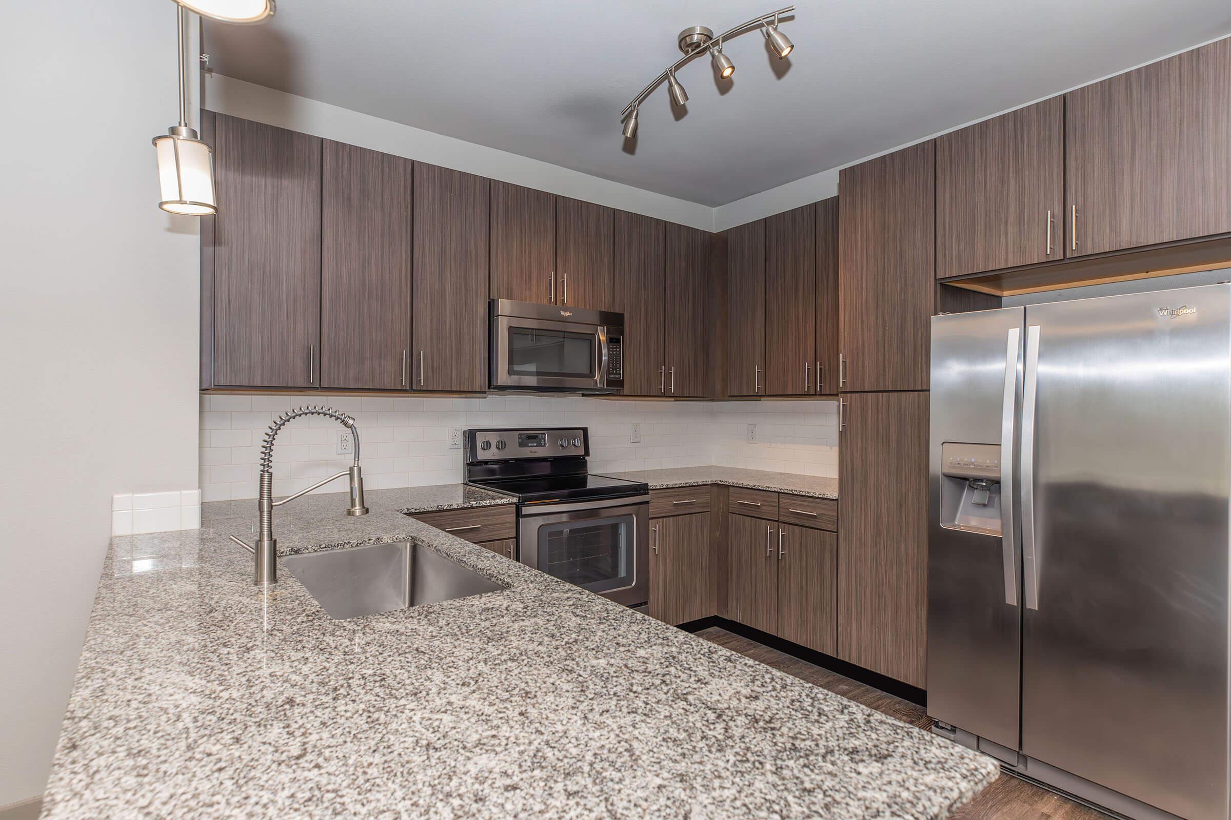 a modern kitchen with stainless steel appliances and wooden cabinets