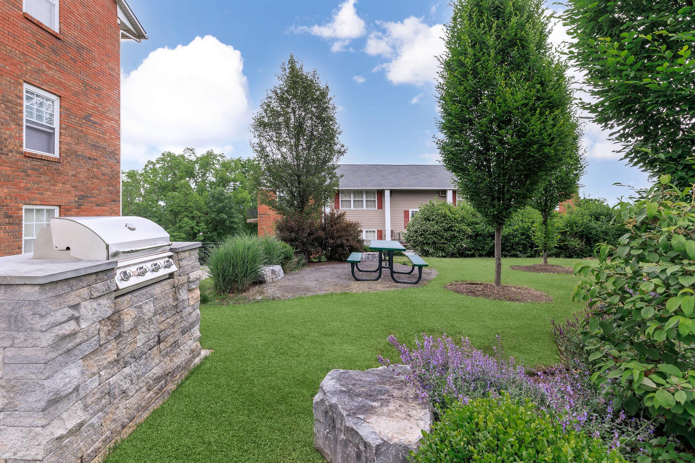 a large brick building with grass in front of a house