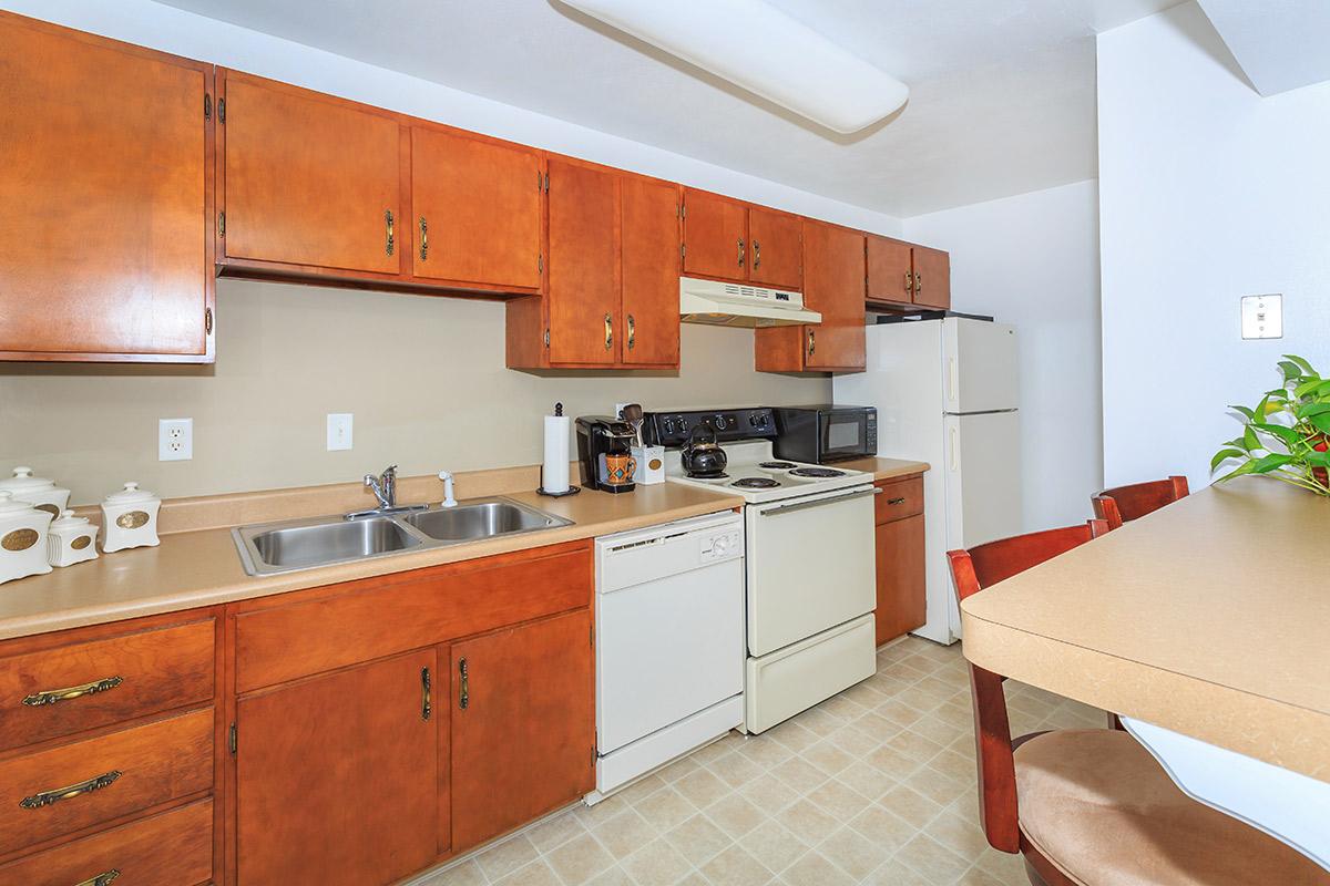 a large kitchen with stainless steel appliances and wooden cabinets