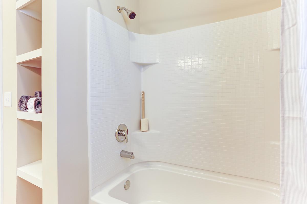 a white tub sitting next to a shower