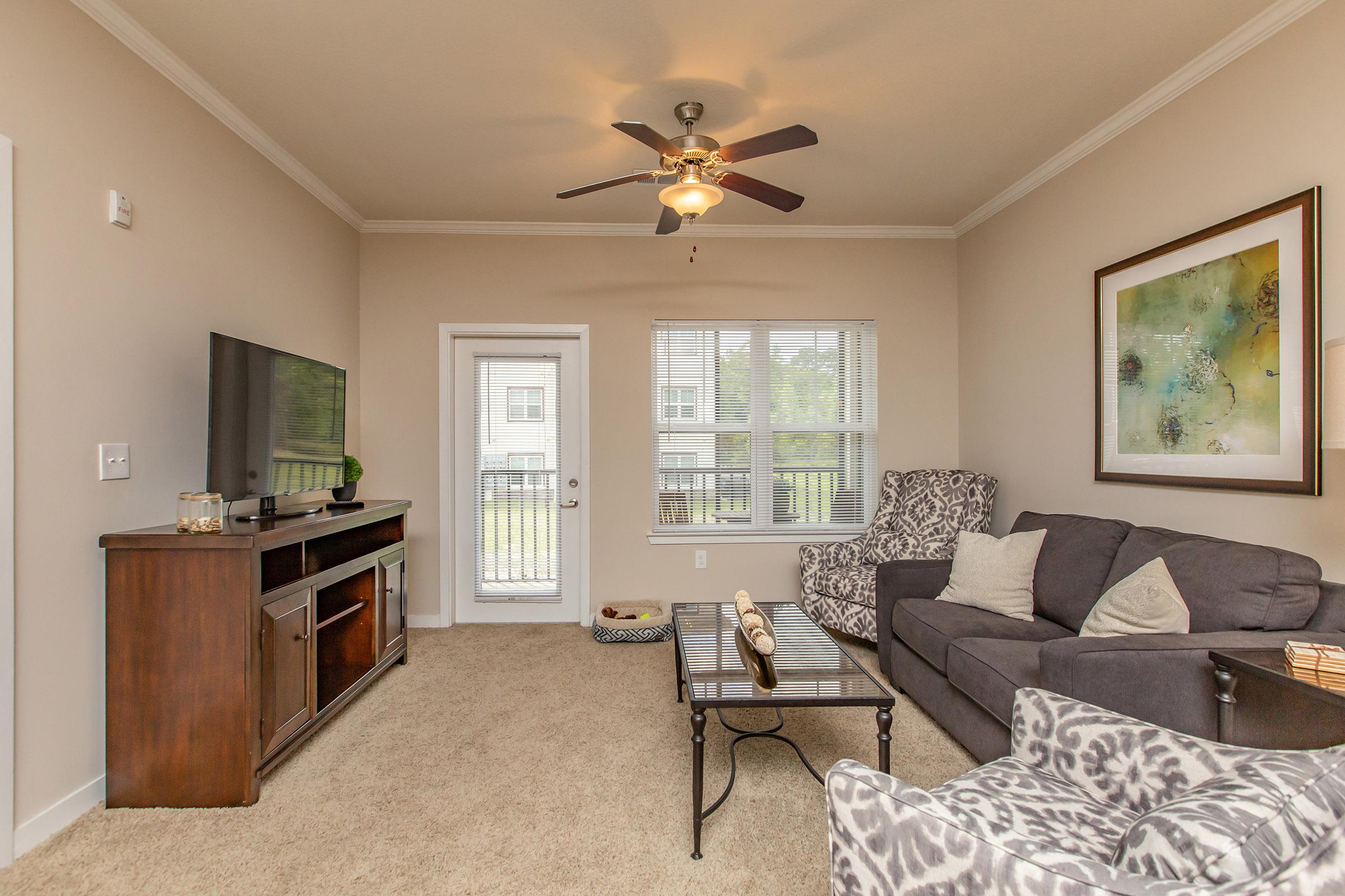 a living room filled with furniture and a large window