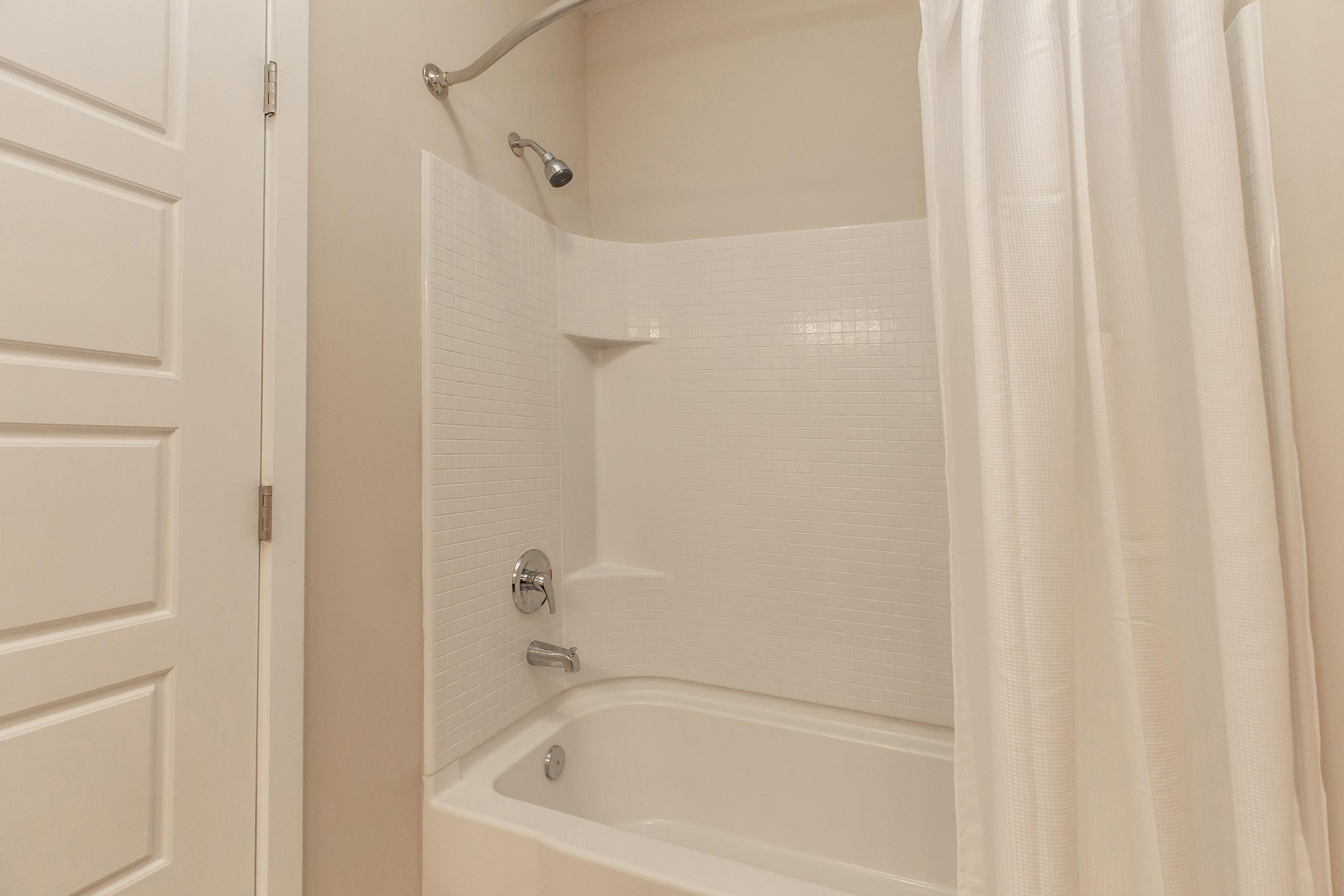 a white tub sitting next to a shower