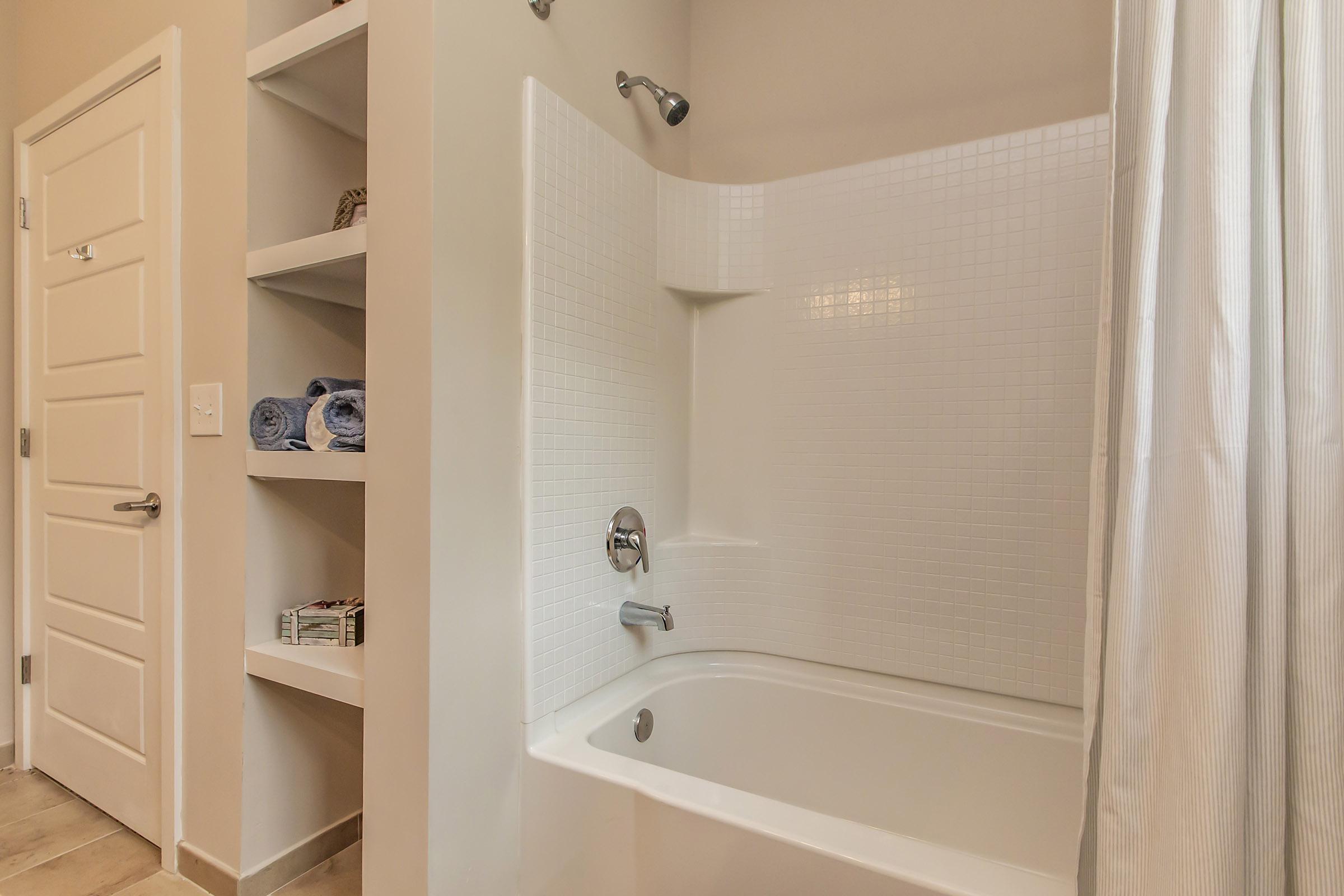 a white sink sitting next to a shower