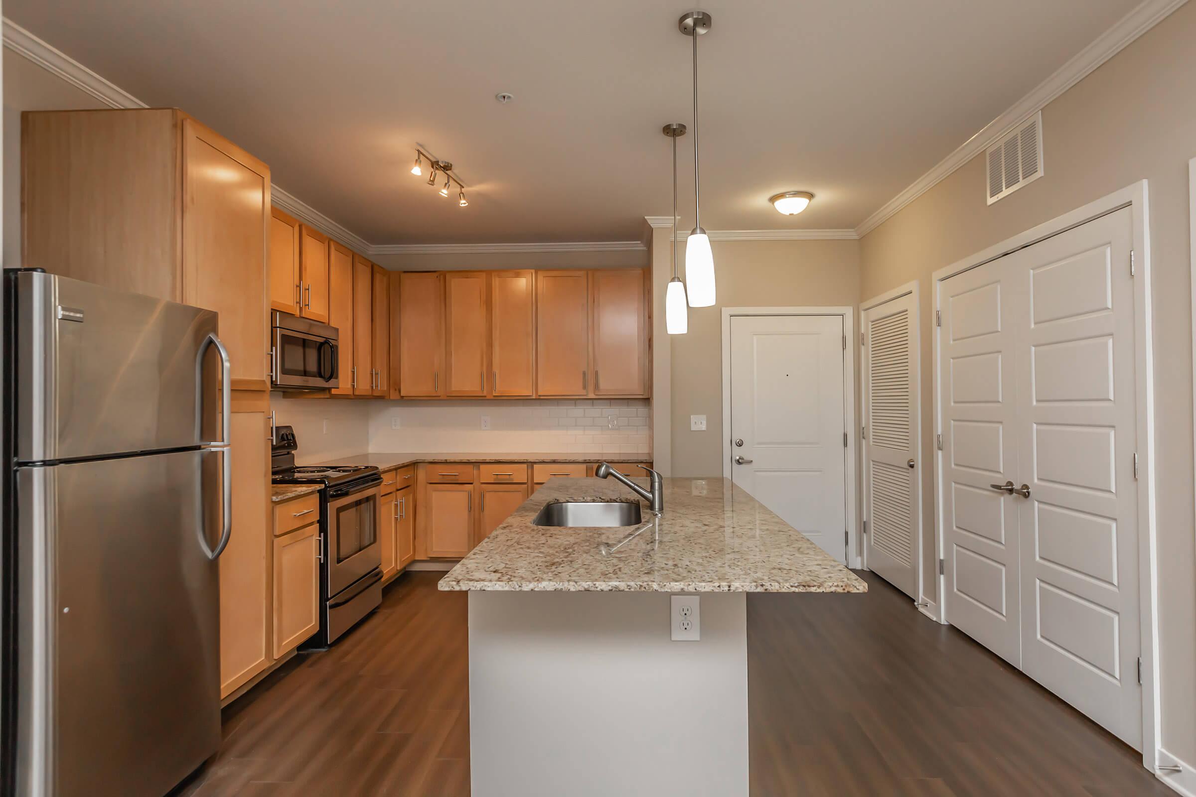 a modern kitchen with stainless steel appliances and wooden cabinets