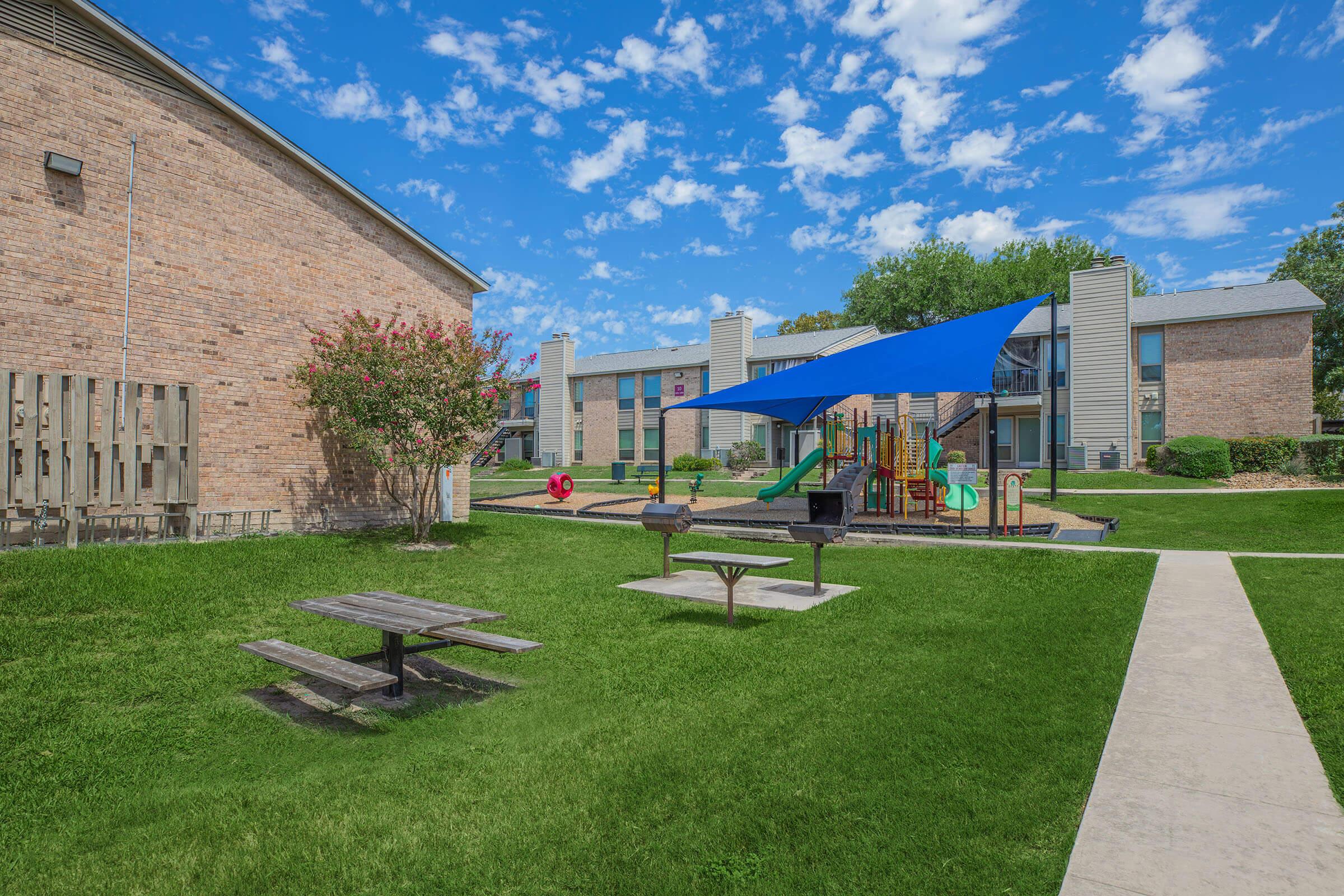 a large lawn in front of a brick building