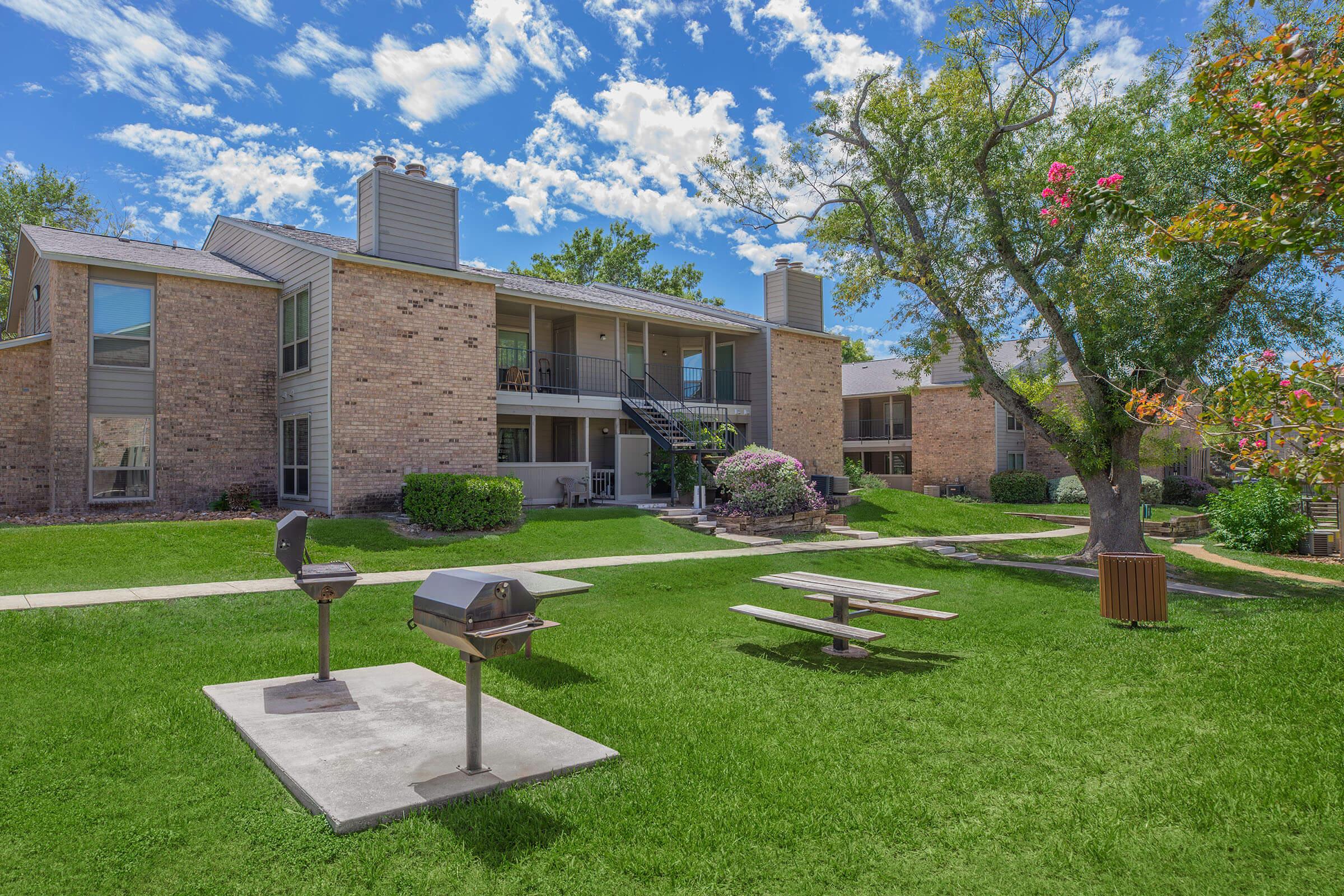 a large lawn in front of a brick building