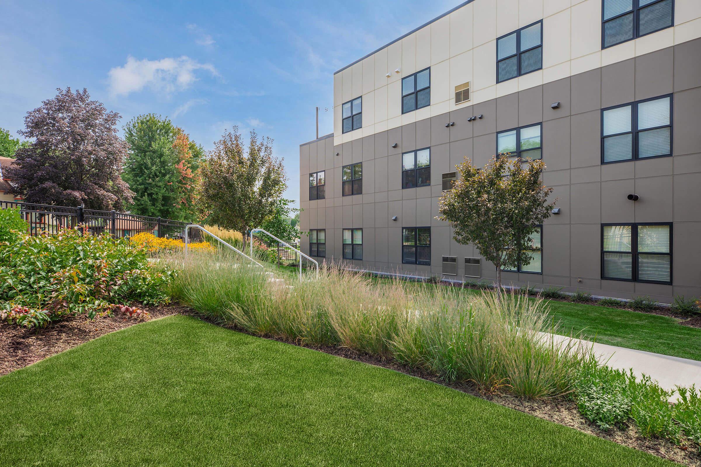 a large brick building with green grass