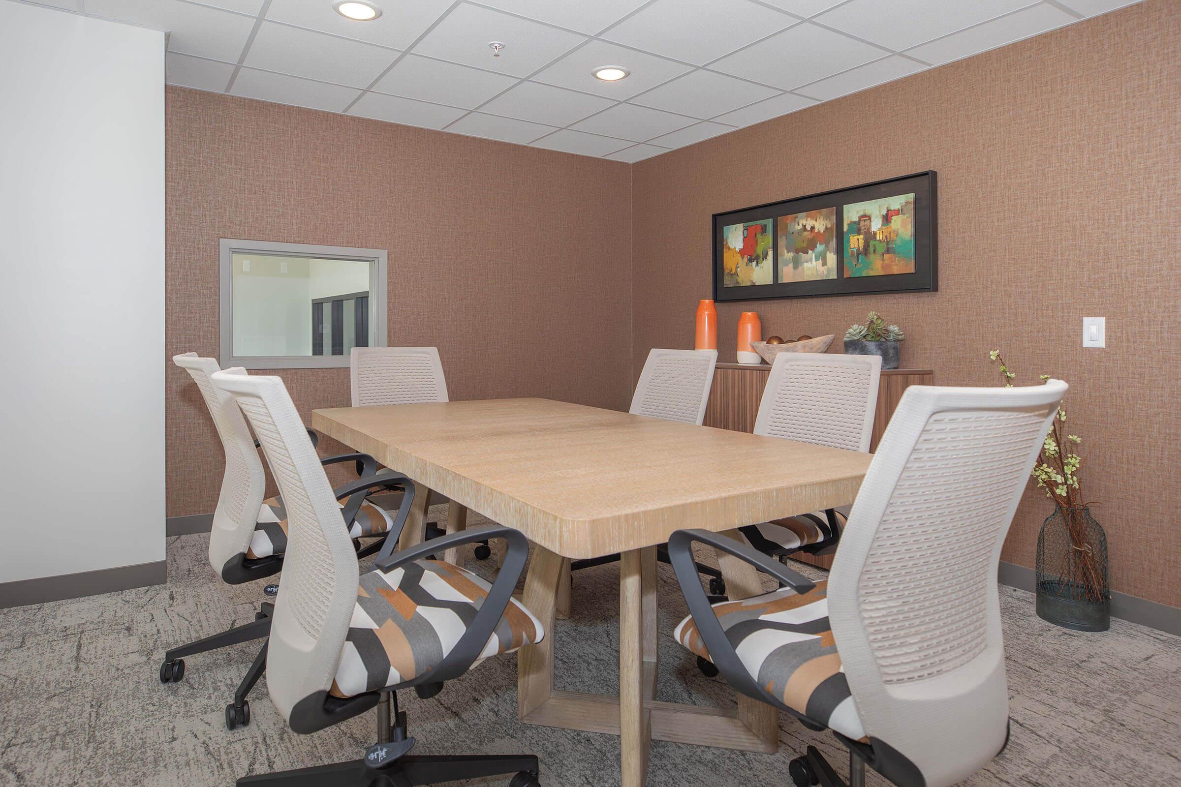 a desk with a computer and a chair in a room