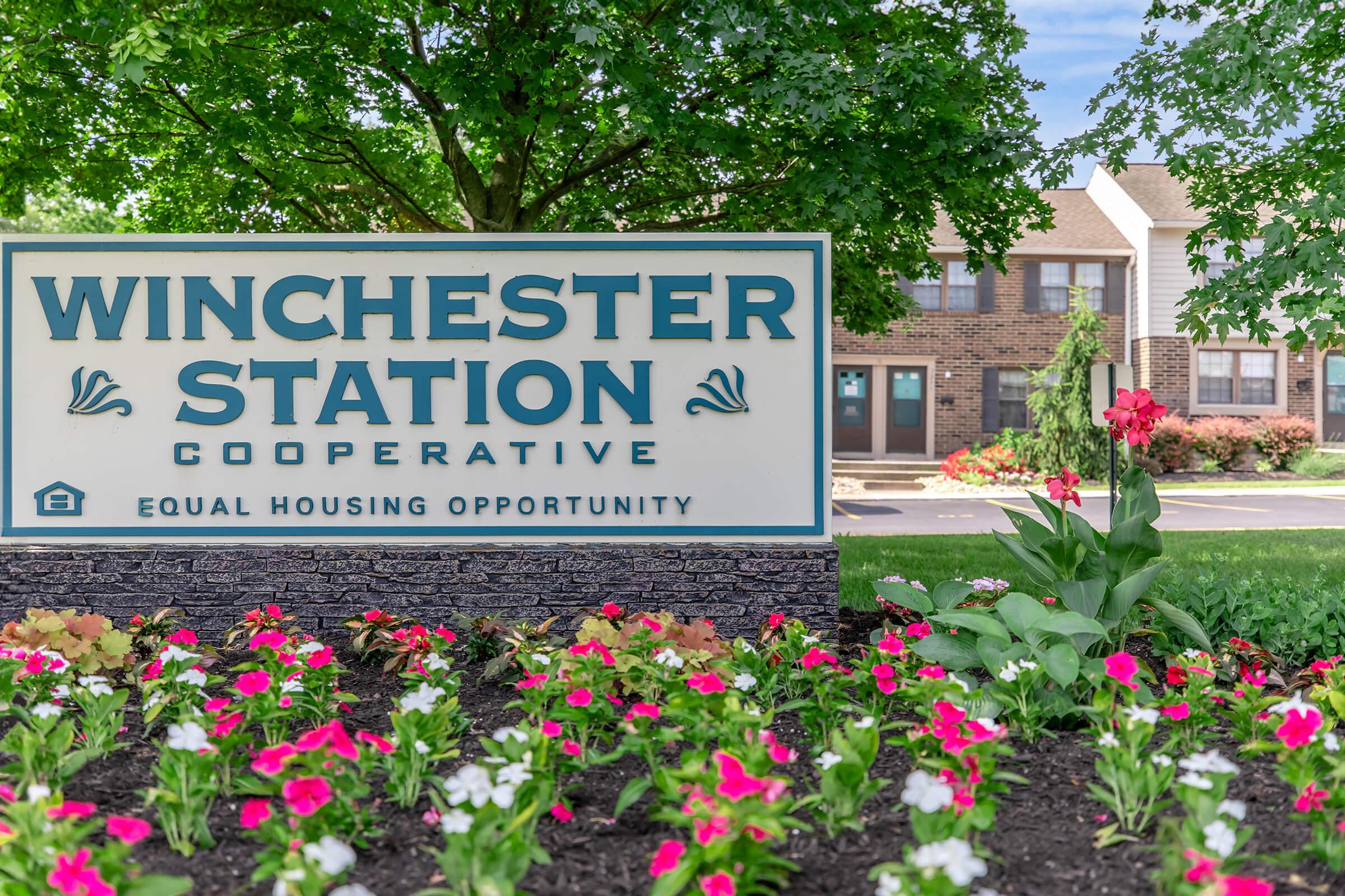 a sign on the side of a flower garden