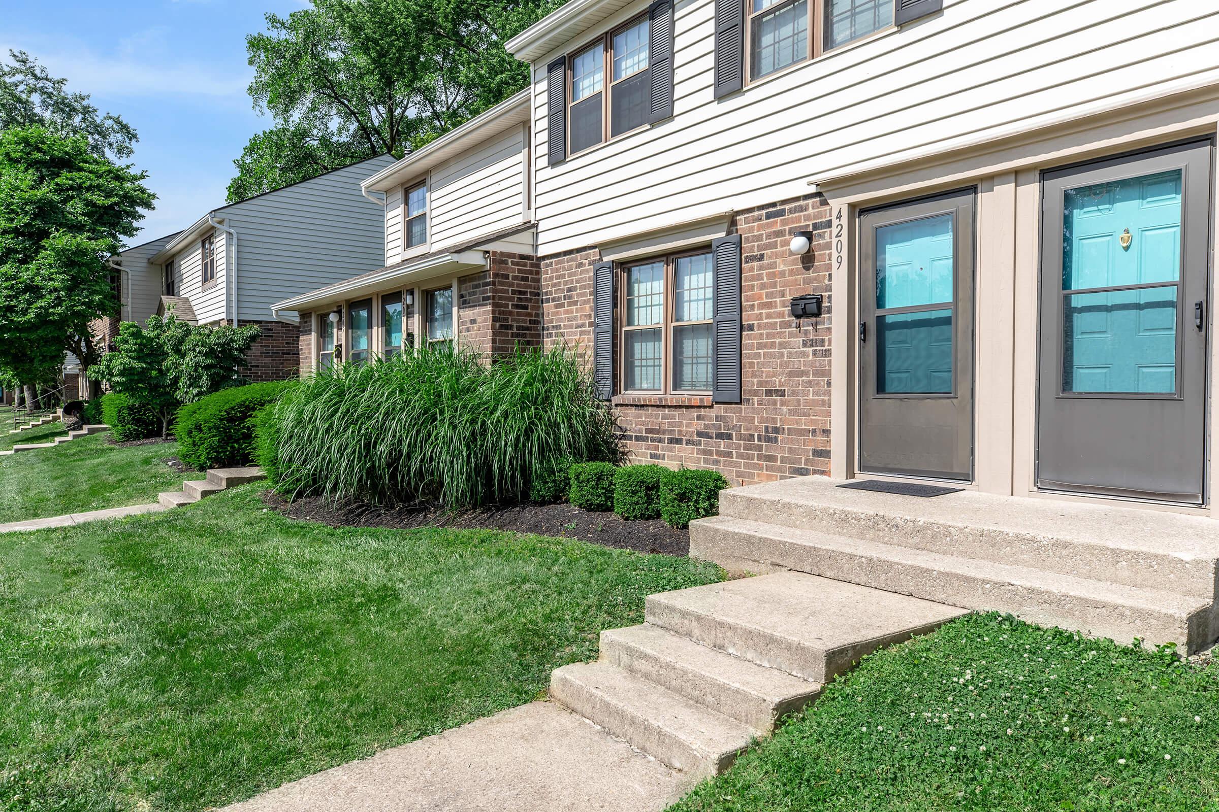 a large brick building with grass in front of a house