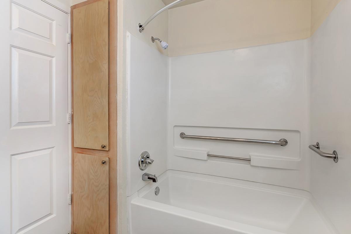 a white tub sitting next to a shower