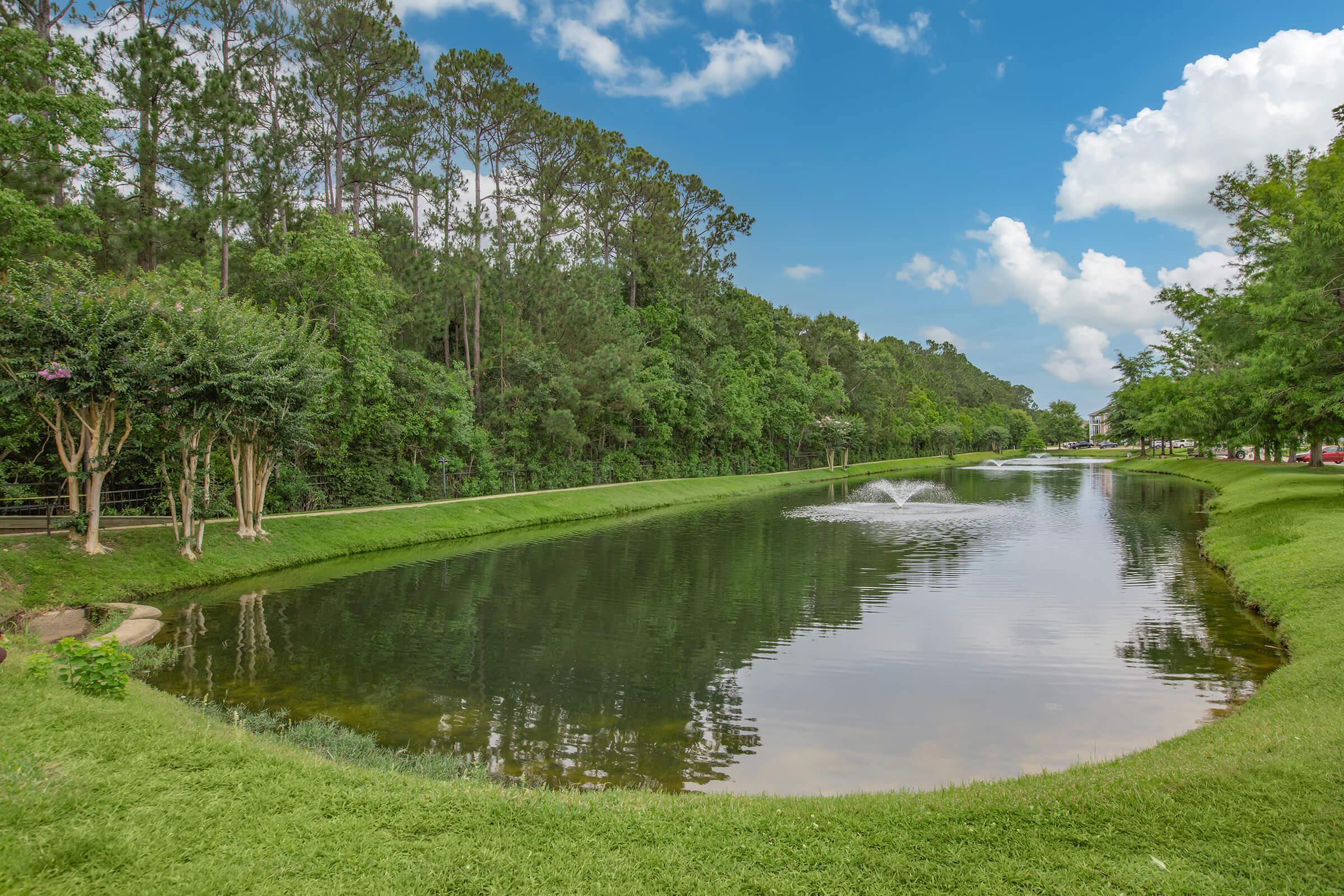 a lake surrounded by green grass and a body of water