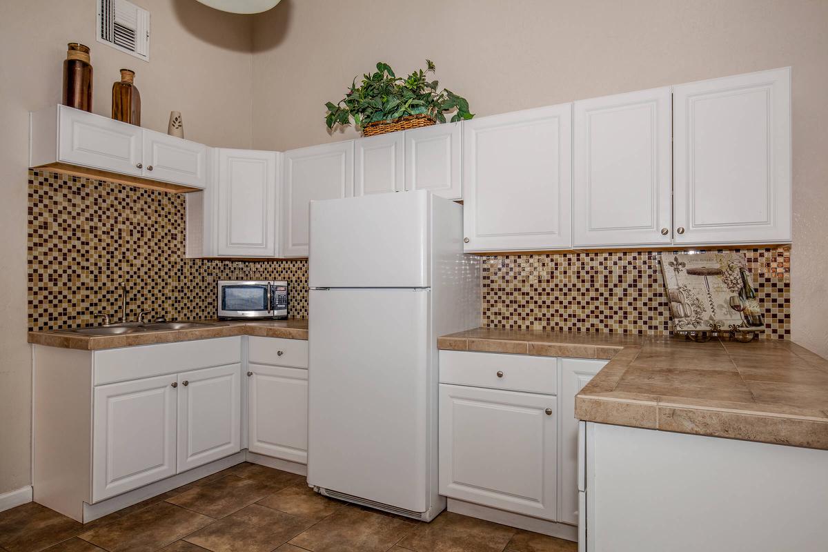 a kitchen with white appliances and wooden cabinets