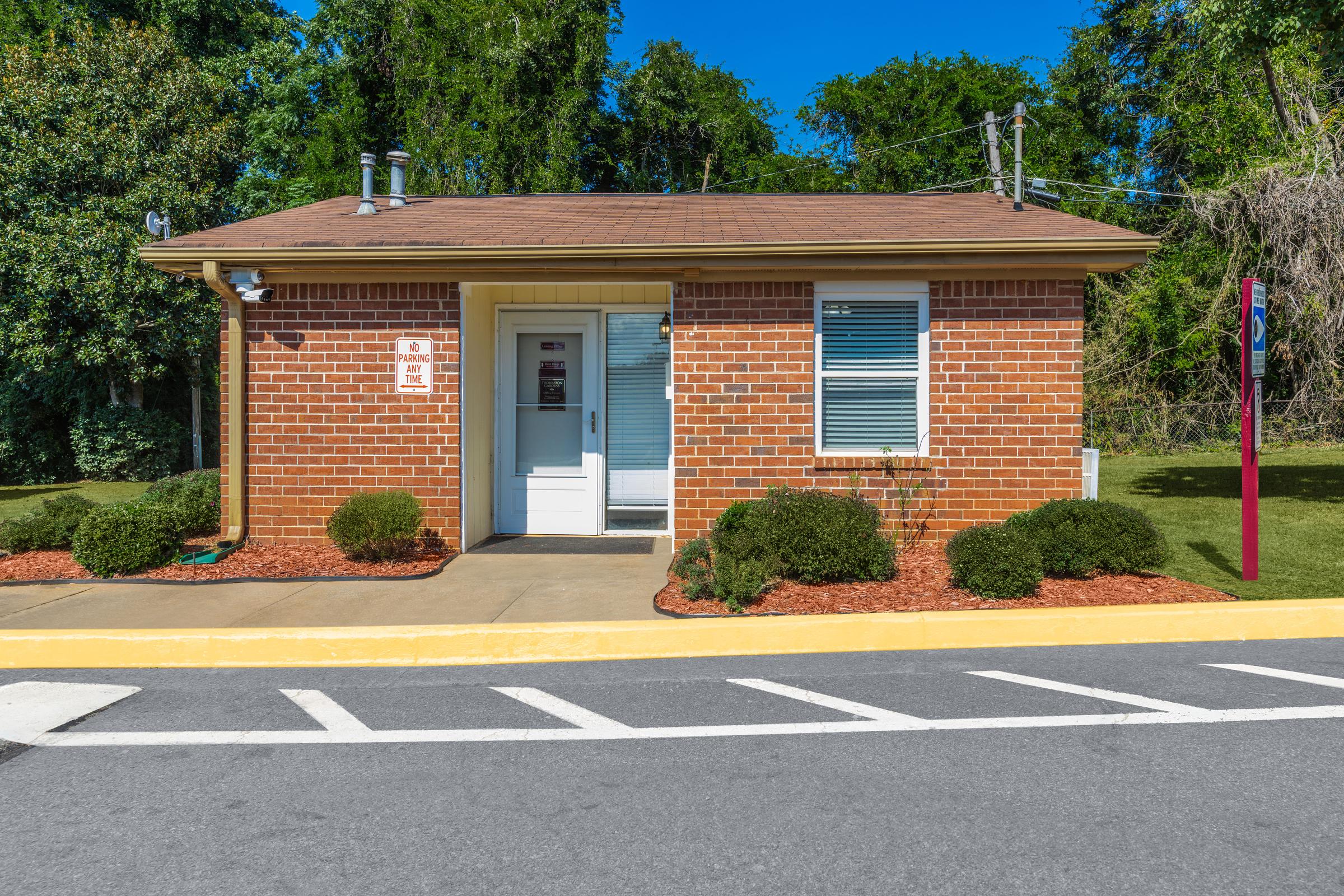 an empty parking lot in front of a house with Thomas Edison House in the background