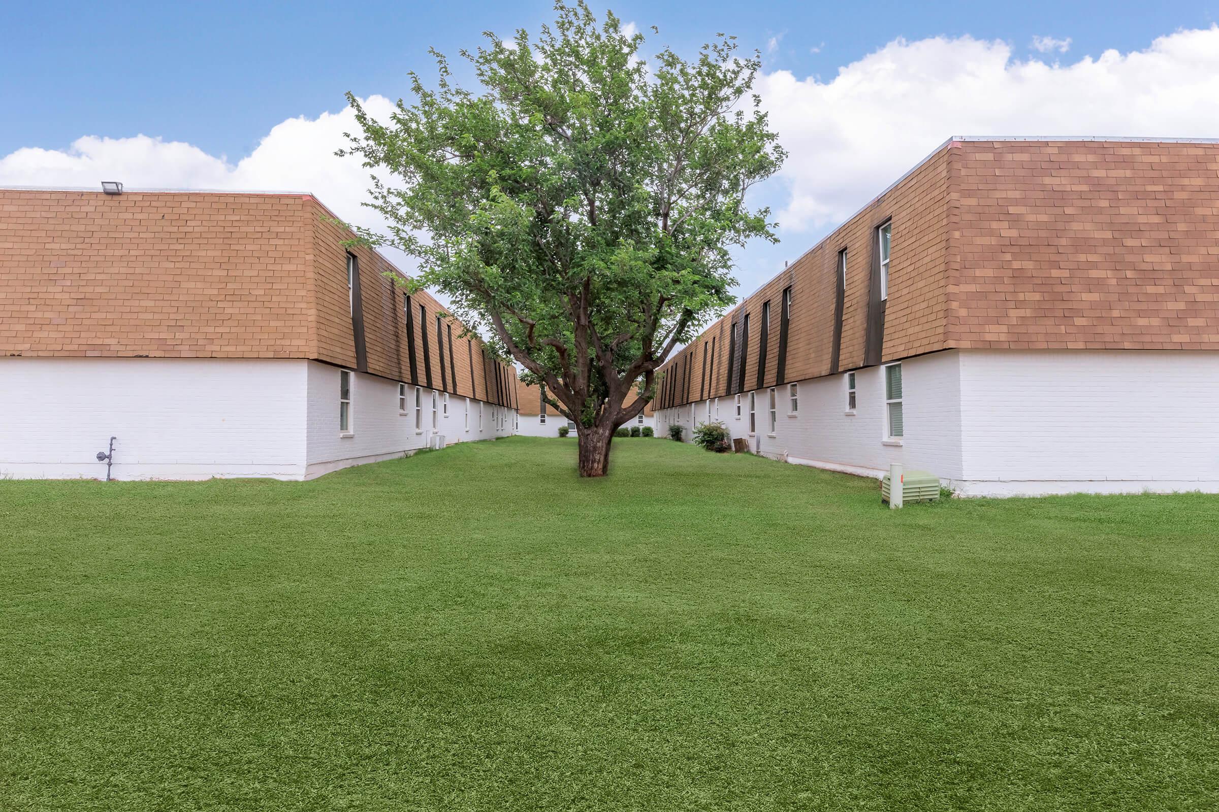 a large brick building with green grass