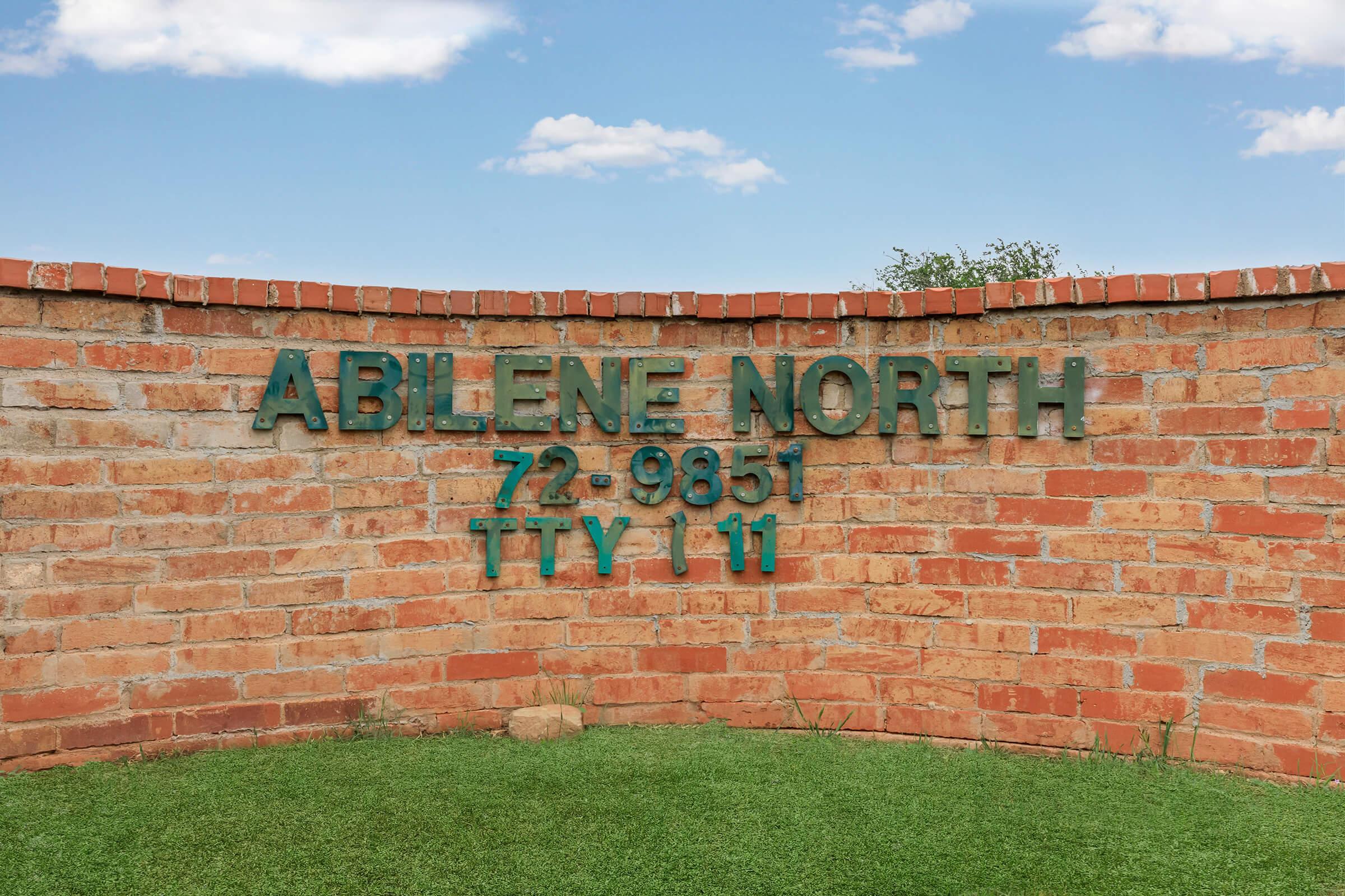 a large brick building with green grass