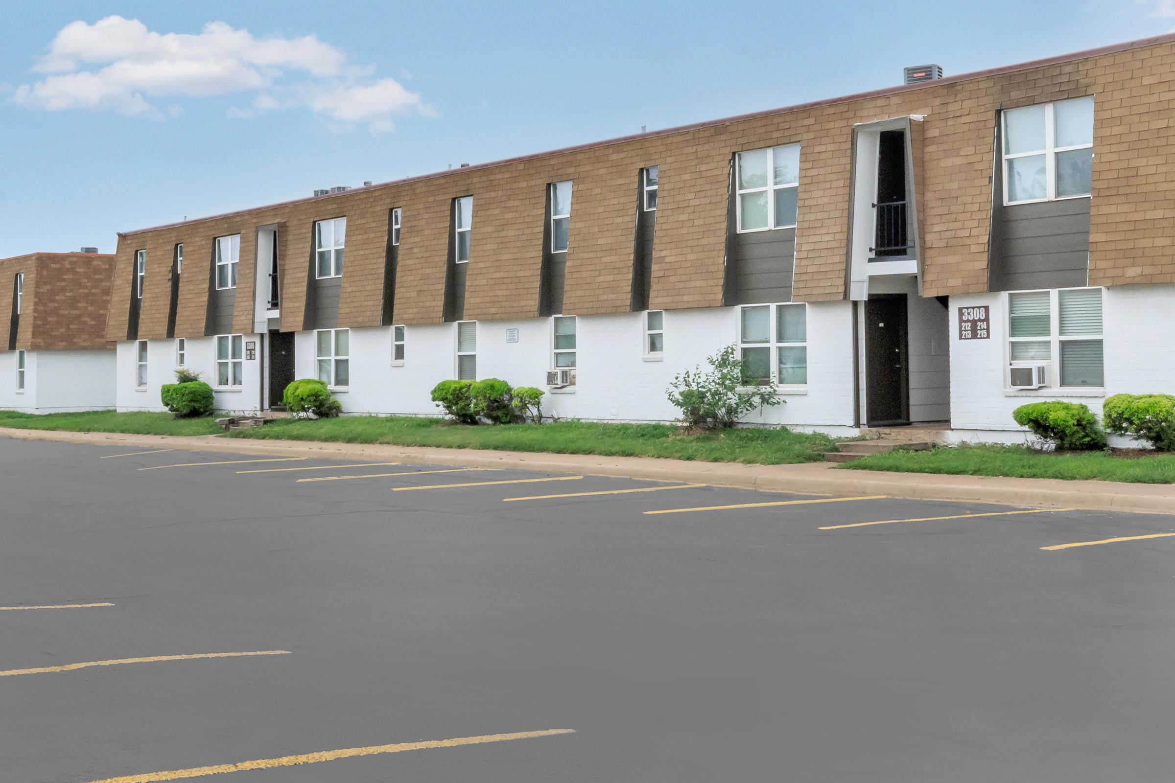 an empty parking lot in front of a brick building