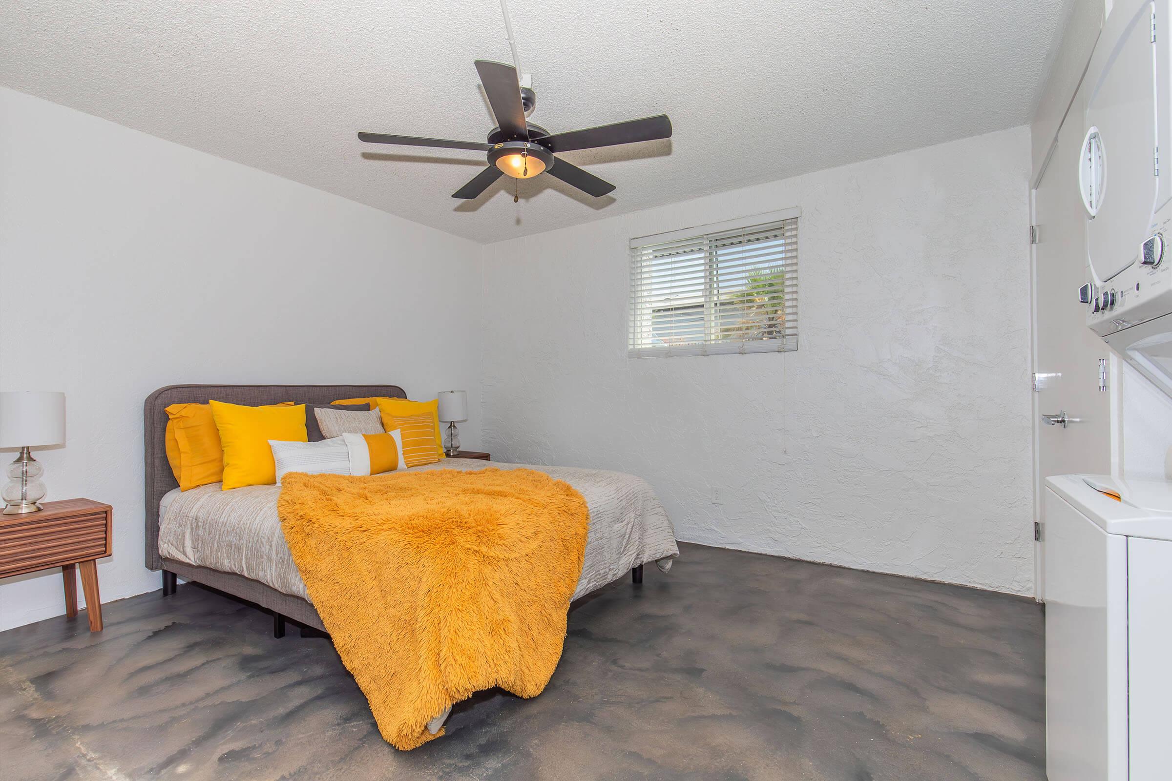 a bedroom with a bed and desk in a room