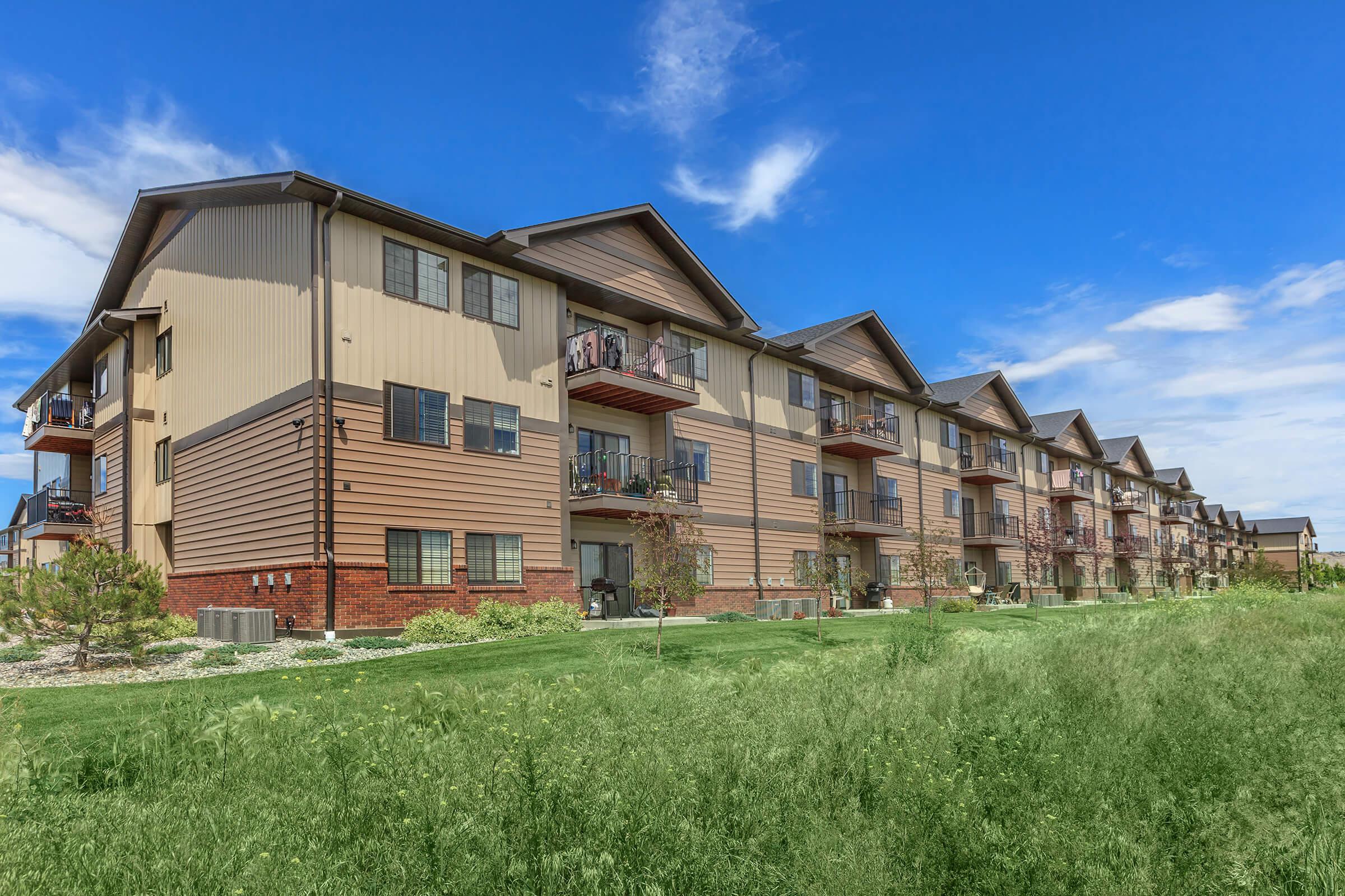 a large brick building with a grassy field