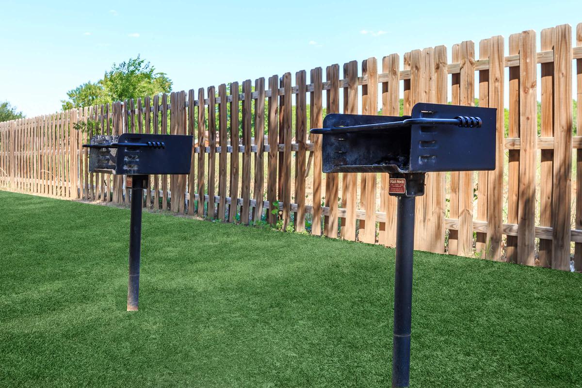 a couple of lawn chairs sitting on top of a wooden fence