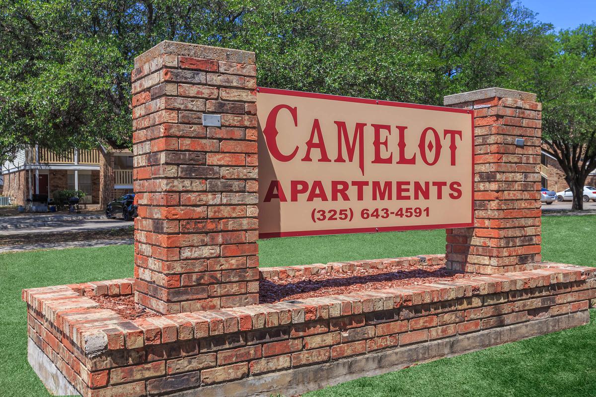 a sign in front of a brick wall