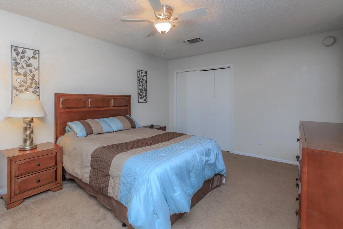 a bedroom with a bed and desk in a room