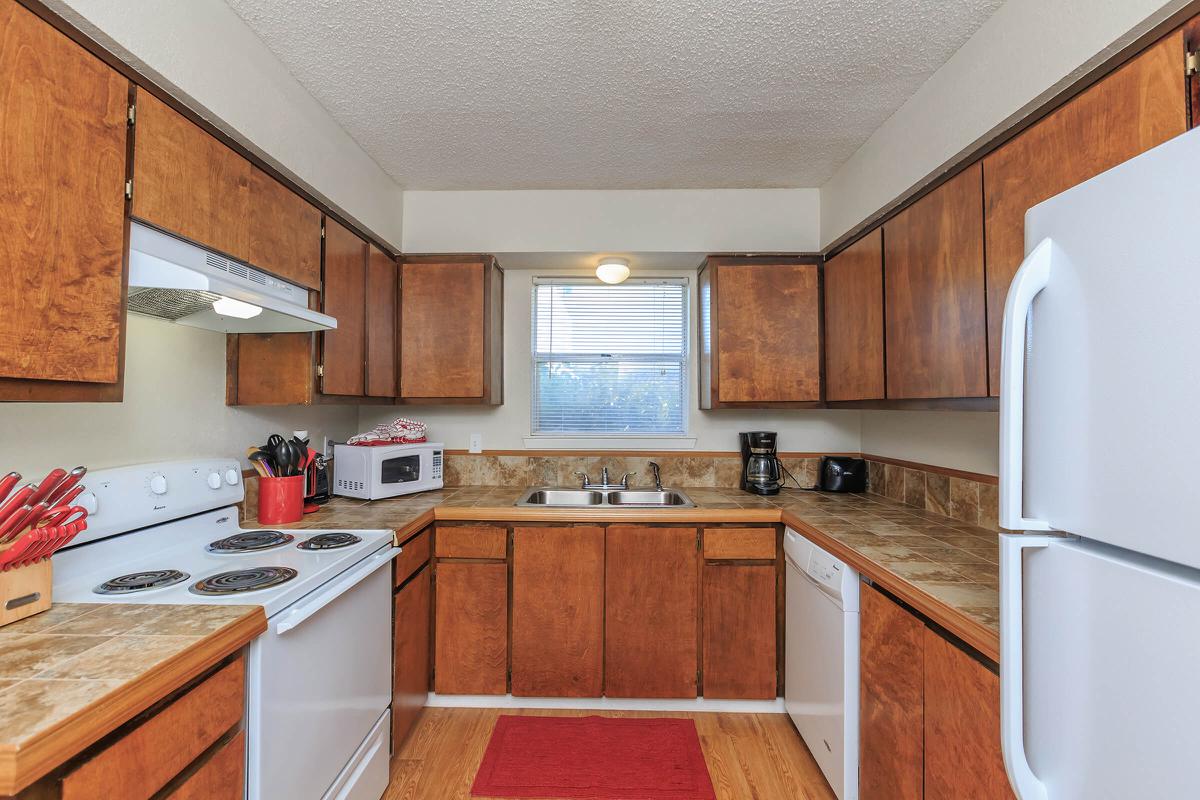 a modern kitchen with stainless steel appliances and wooden cabinets