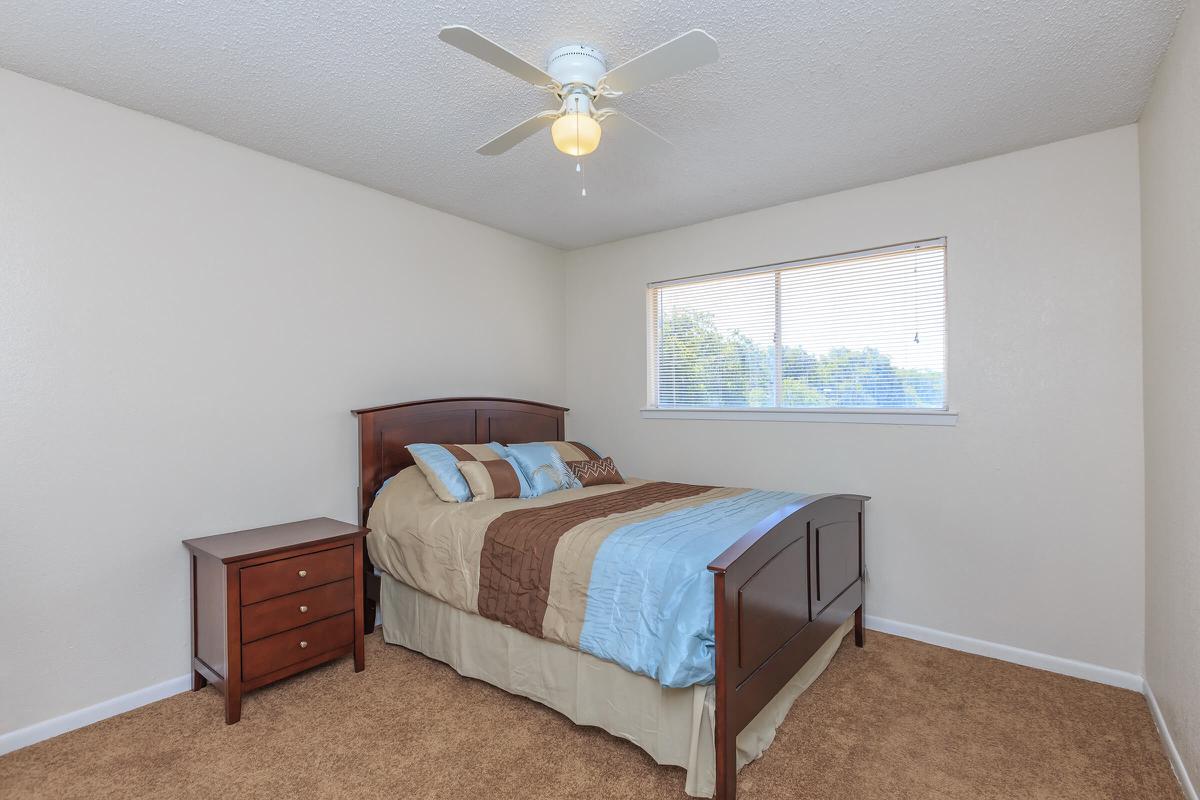 a bedroom with a bed and desk in a small room